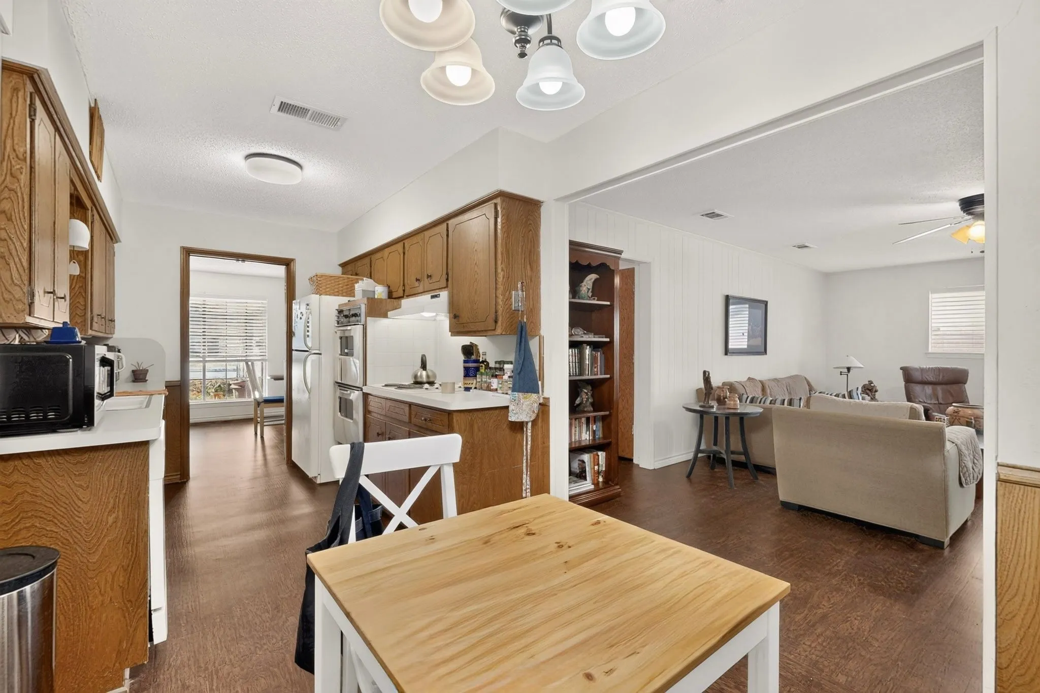 Kitchen with wood-finish cabinetry, white countertops, and wood-finish flooring