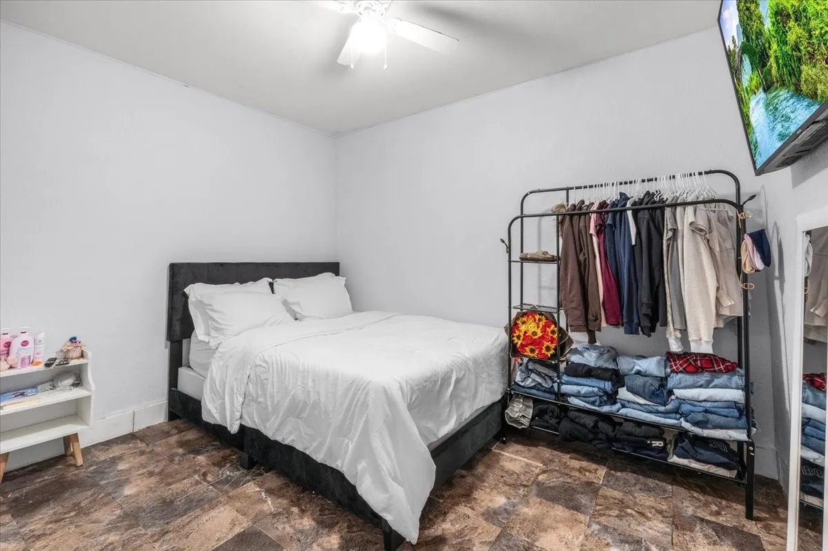 Wood-finish flooring with white walls and a ceiling fan