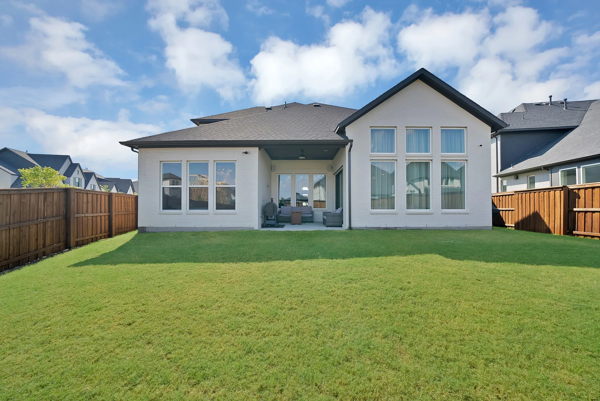 Expansive green lawn with a privacy fence