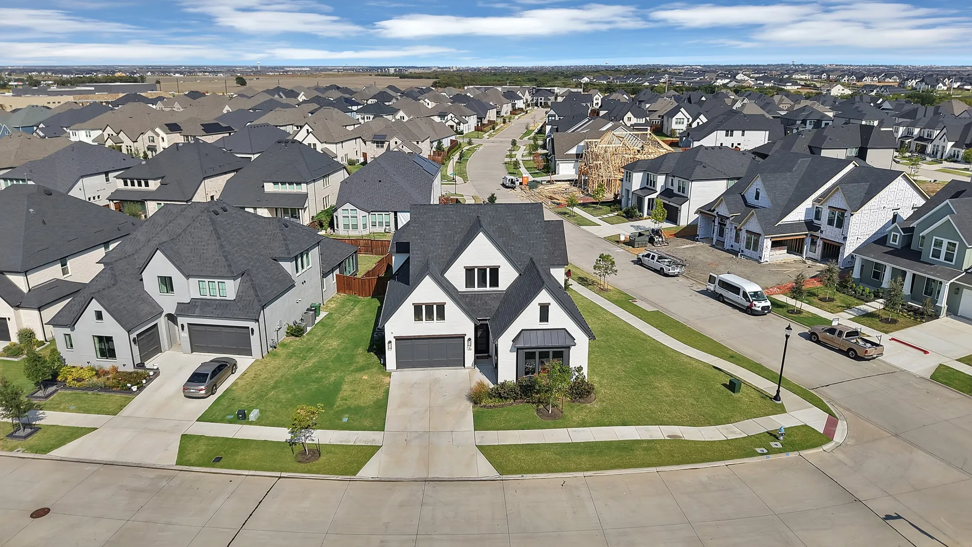 Modern residence with a multi-gabled roof, symmetrical facade, attached two-car garage, and a concrete driveway