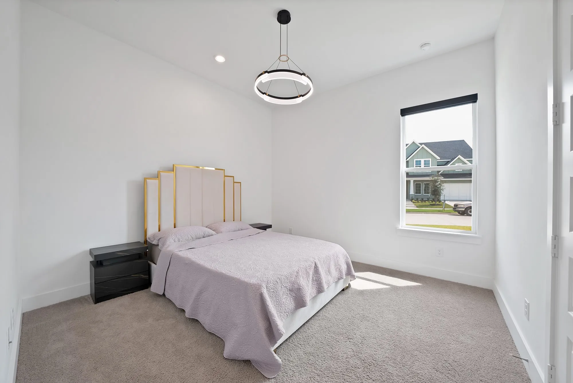 Recessed lighting, sloped ceiling, window with roller shade, pendant light fixture, and carpeted flooring