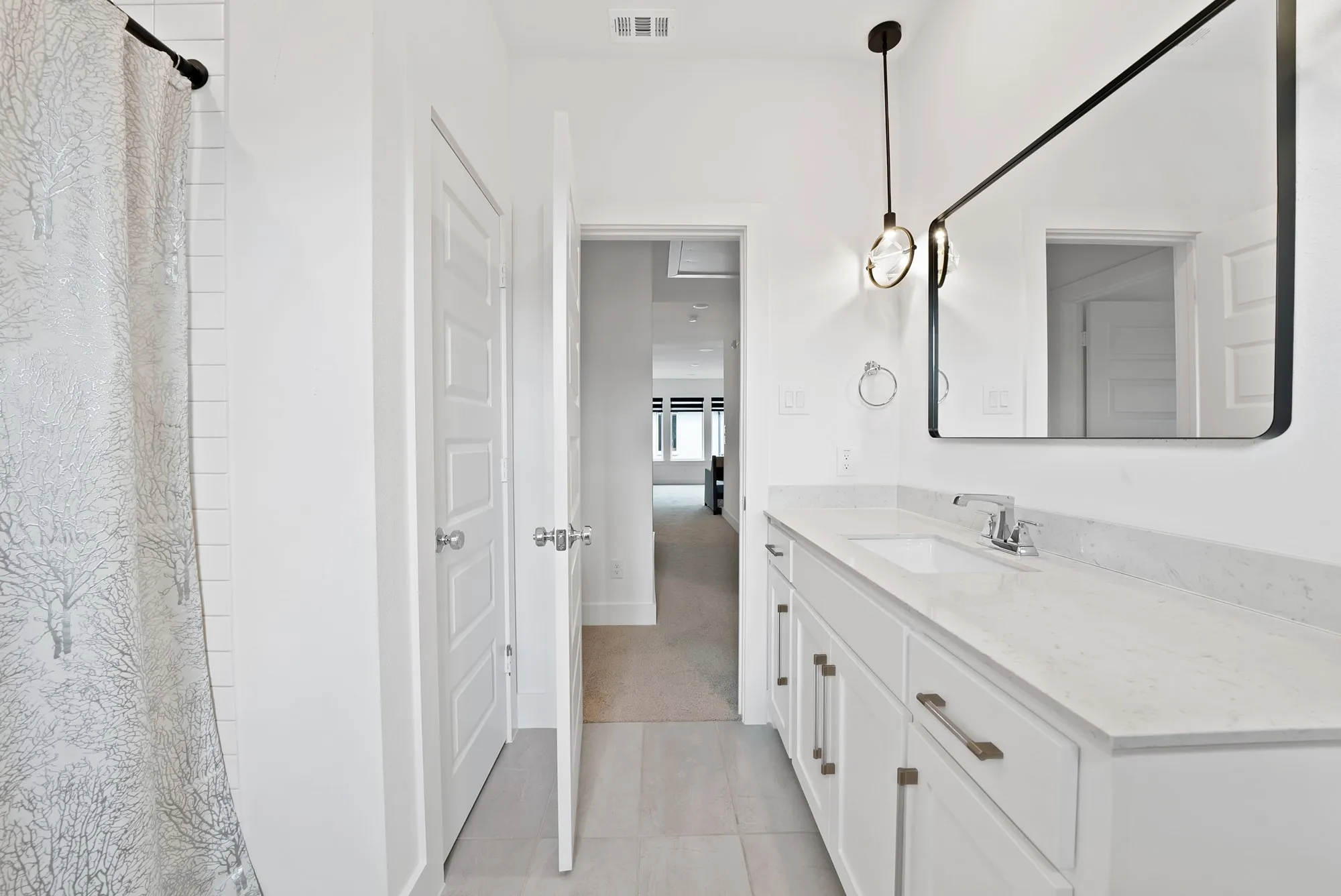 Bathroom vanity with an integrated sink, polished chrome faucet, and a large framed mirror