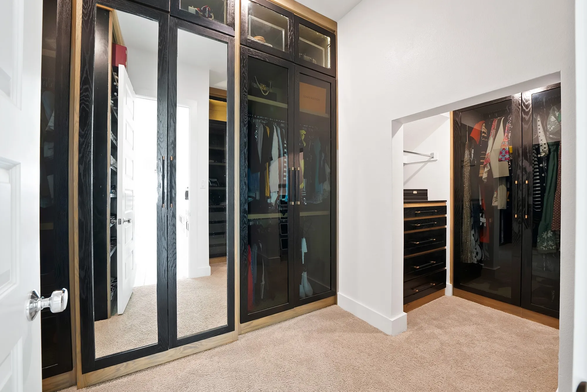 Built-in cabinetry with glass-front doors, mirrored panels, recessed lighting, and integrated drawers