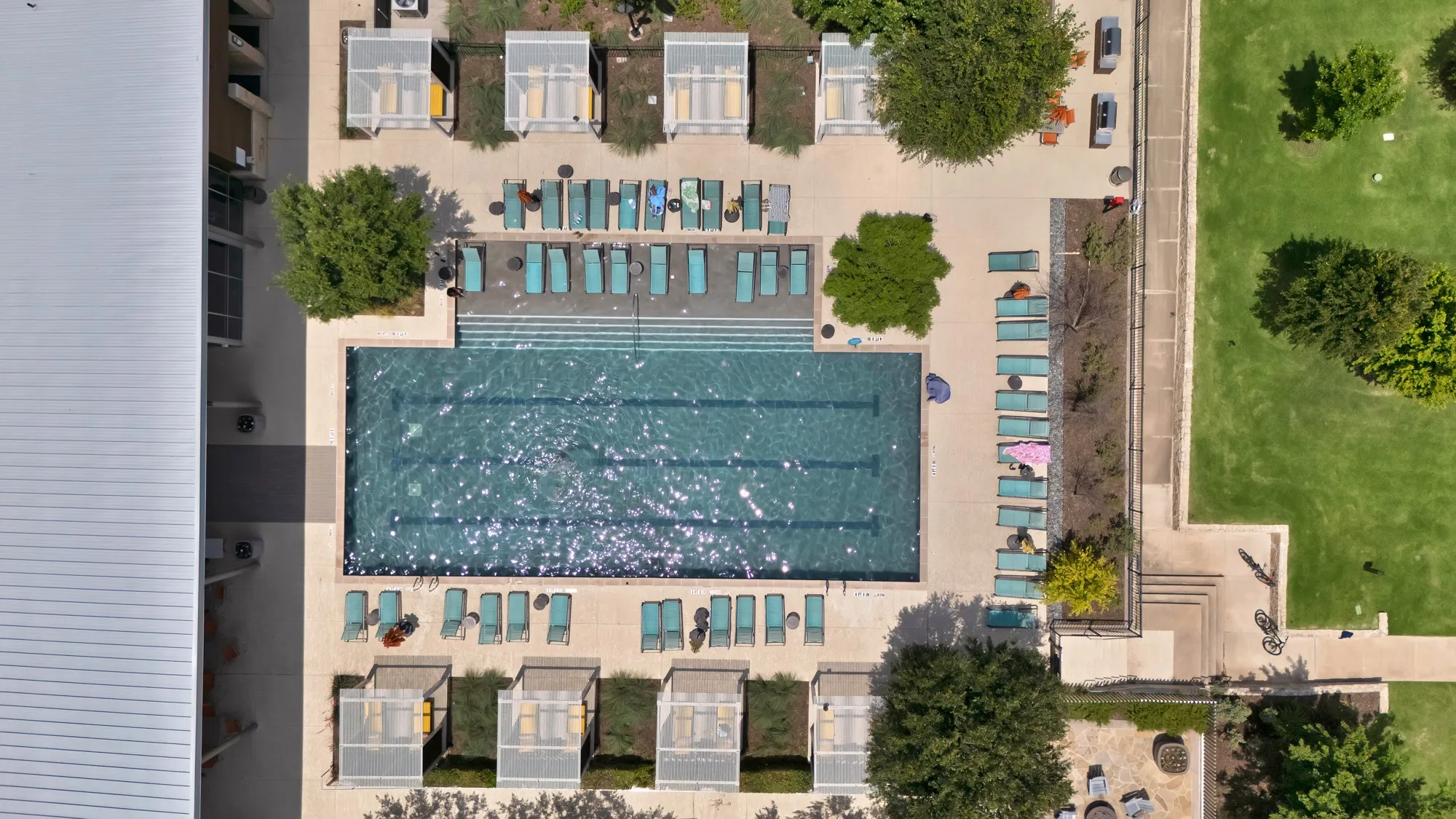 Rectangular swimming pool with integrated steps, surrounded by a paved deck