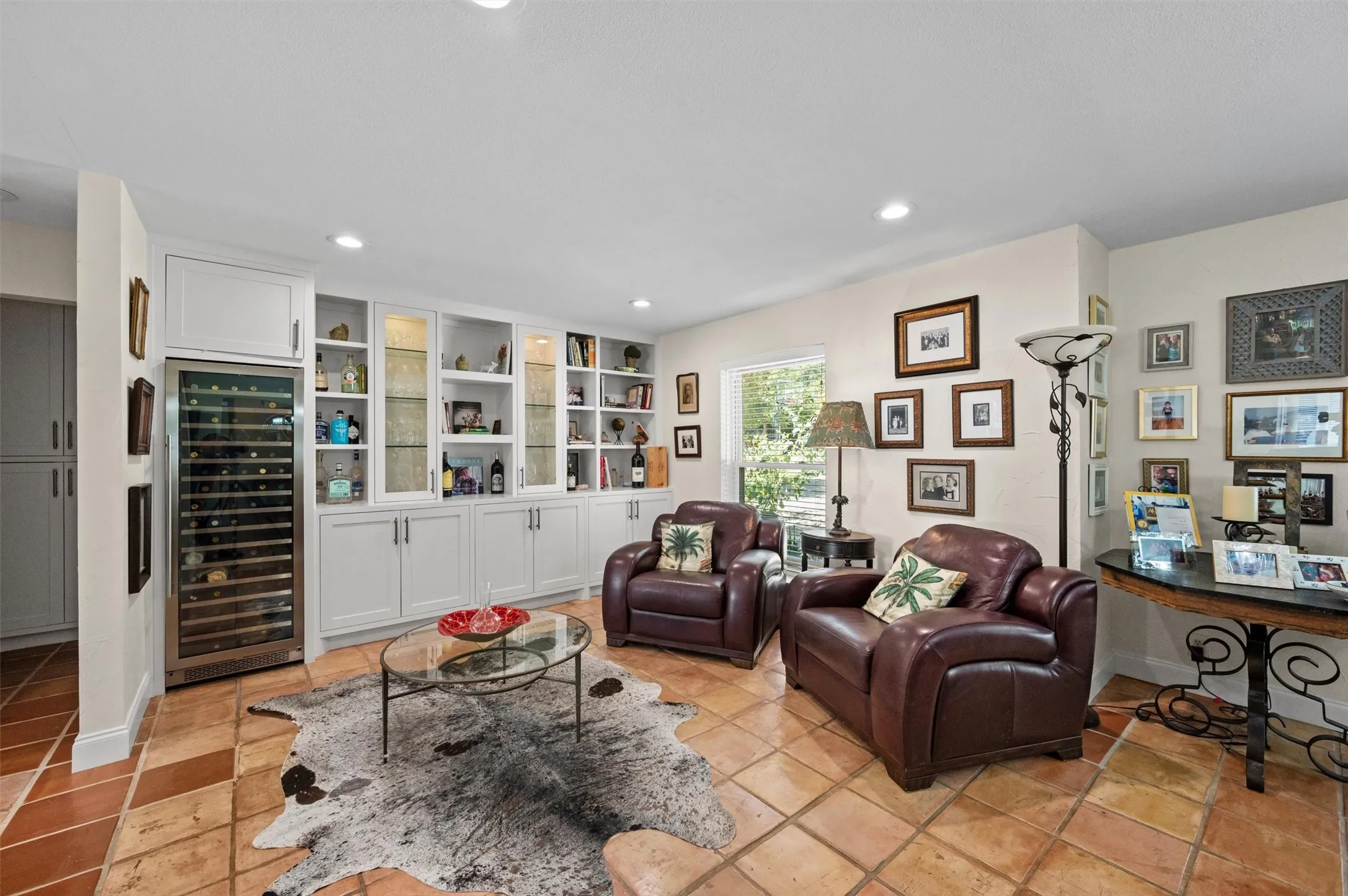 Built-in cabinetry with glass display panels, recessed lighting, tile flooring, and a built-in wine cooler
