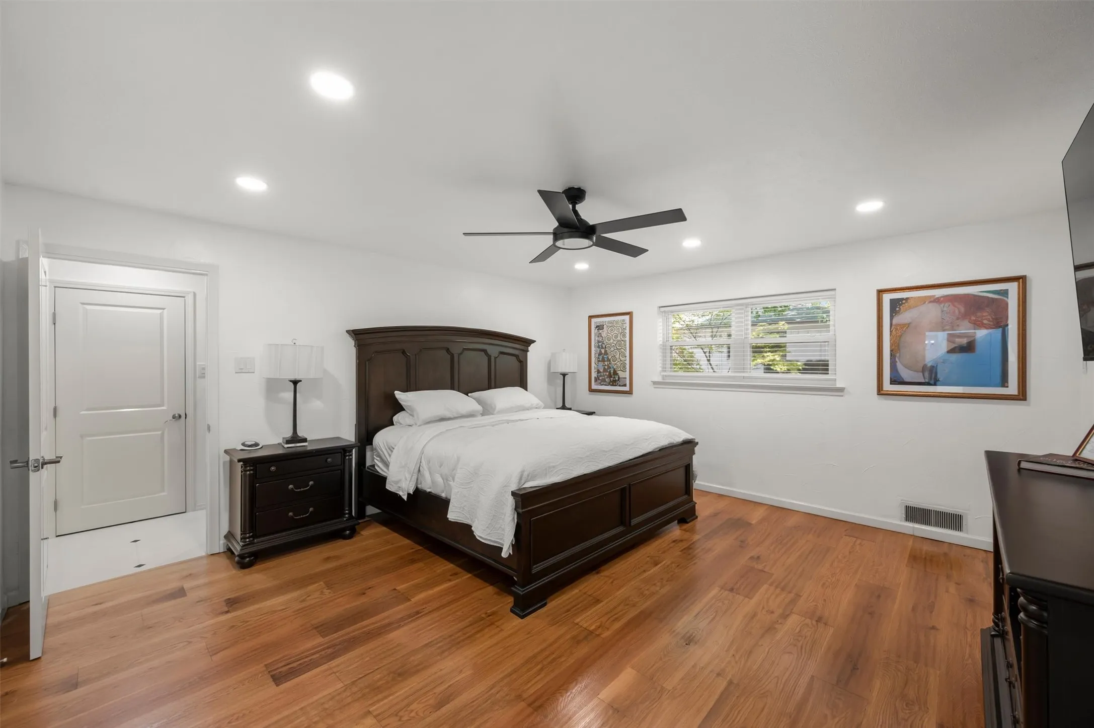 Hardwood flooring, recessed lighting, ceiling fan, white paneled door, and a window with blinds