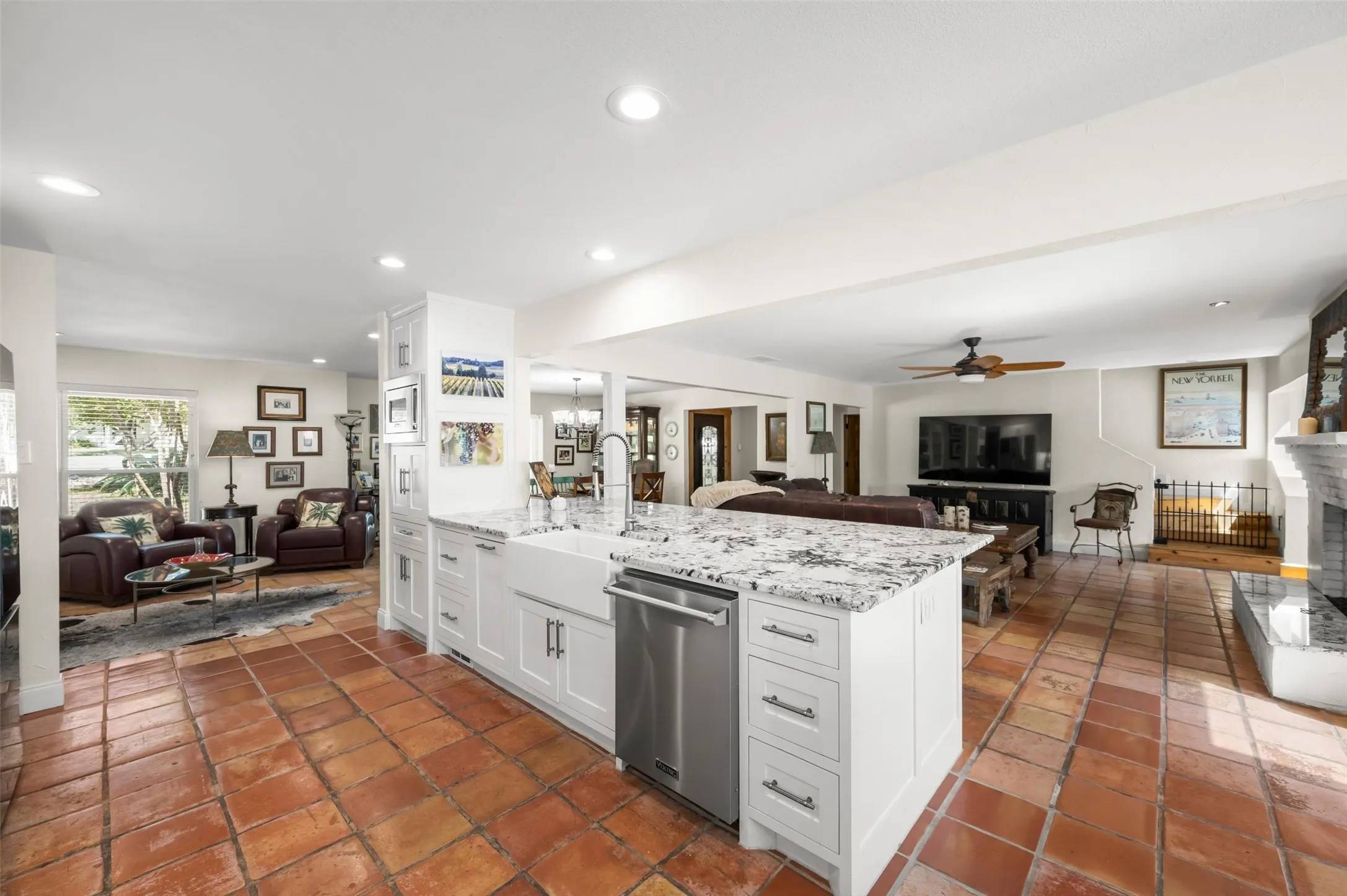 Kitchen island with white cabinetry, granite countertop, farmhouse sink, and stainless steel dishwasher