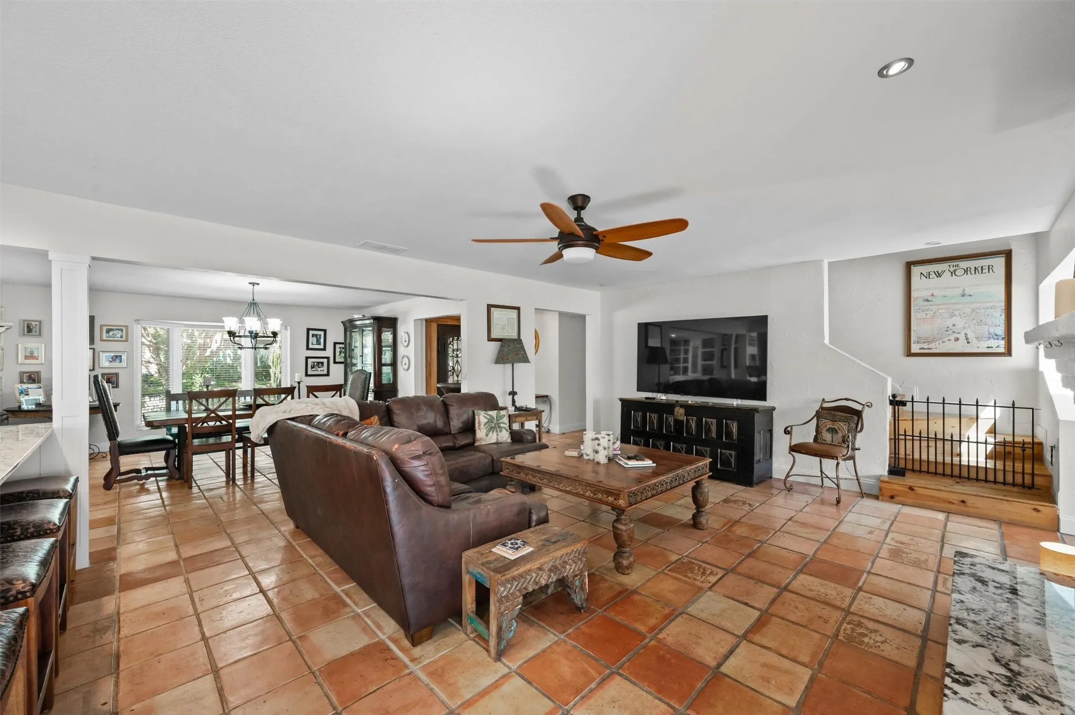 Spacious living area featuring large format tile flooring, recessed lighting, and a ceiling fan