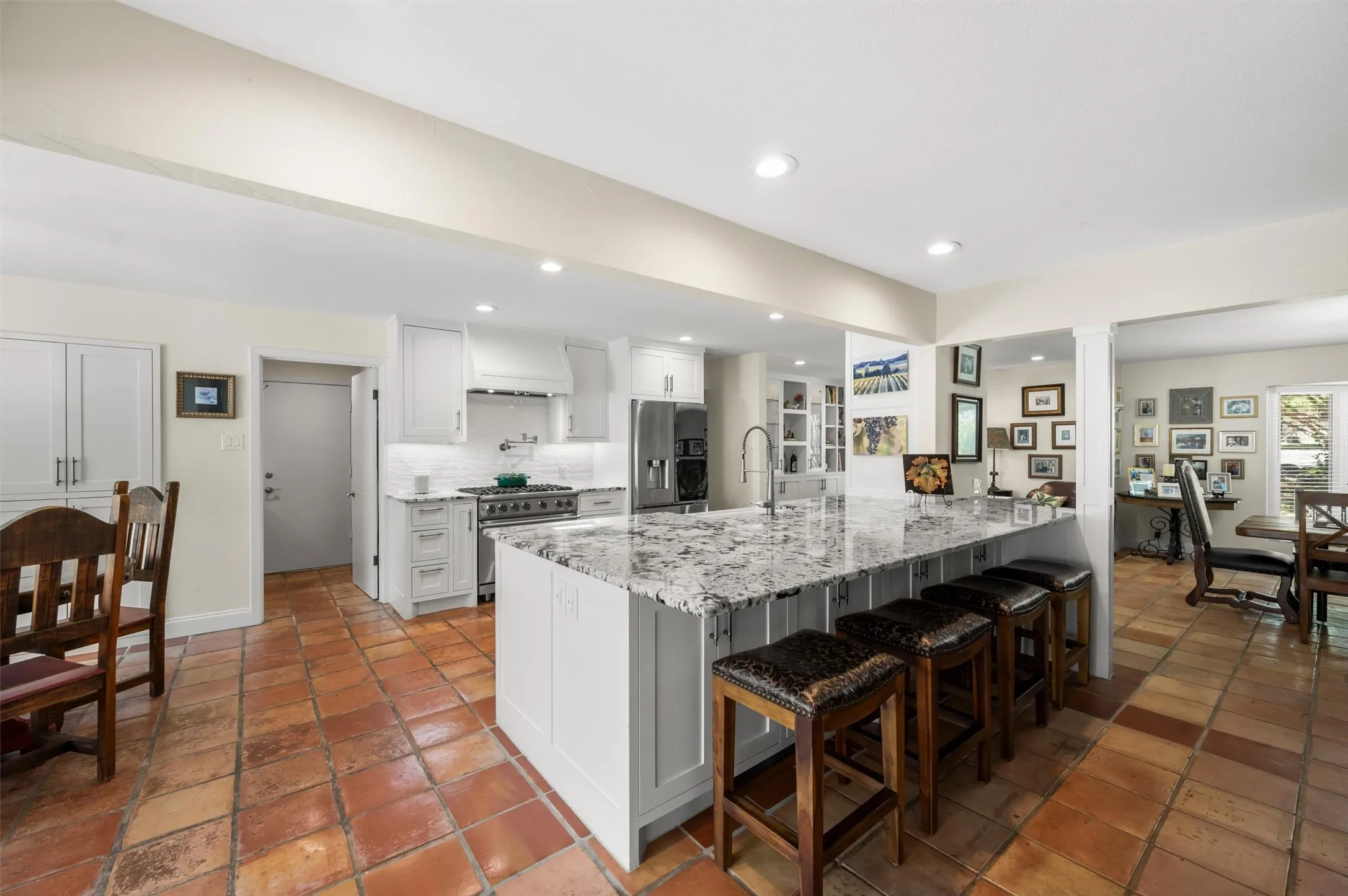 Large kitchen island with a stone countertop and seating for four