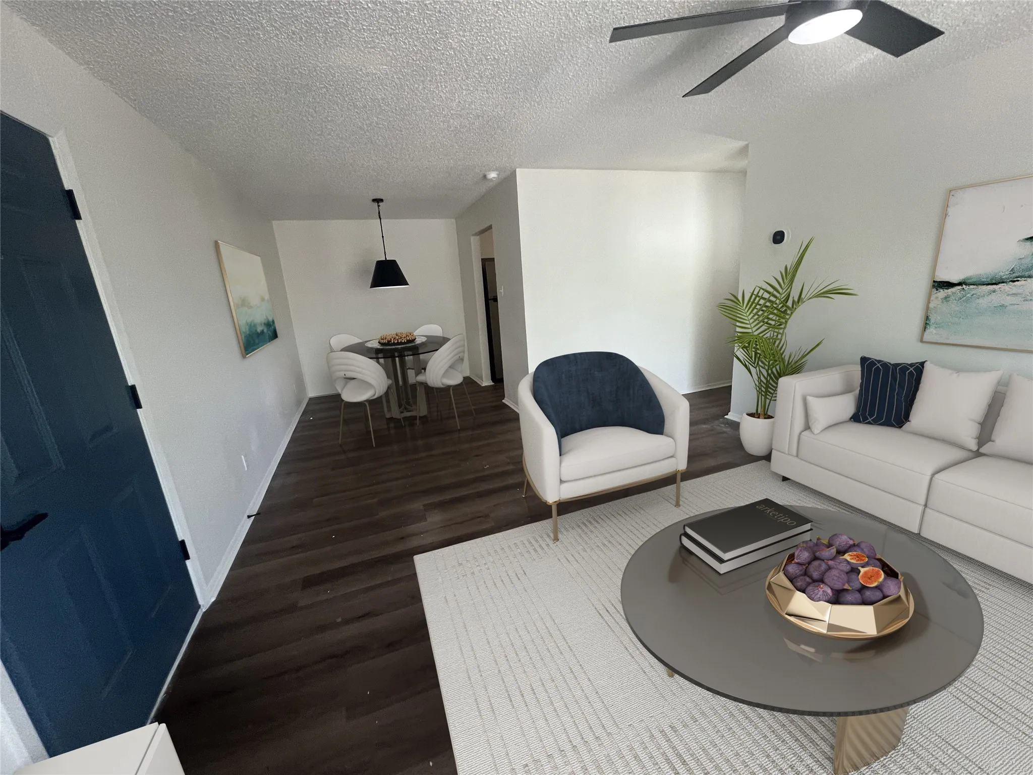 Living room with a textured ceiling, wood finished floors, and a ceiling fan