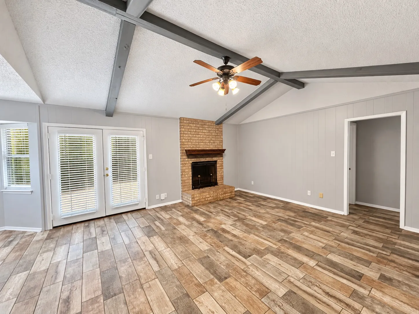 Laminate wood floording, woodburning fireplace and french doors to the wooded back yard.