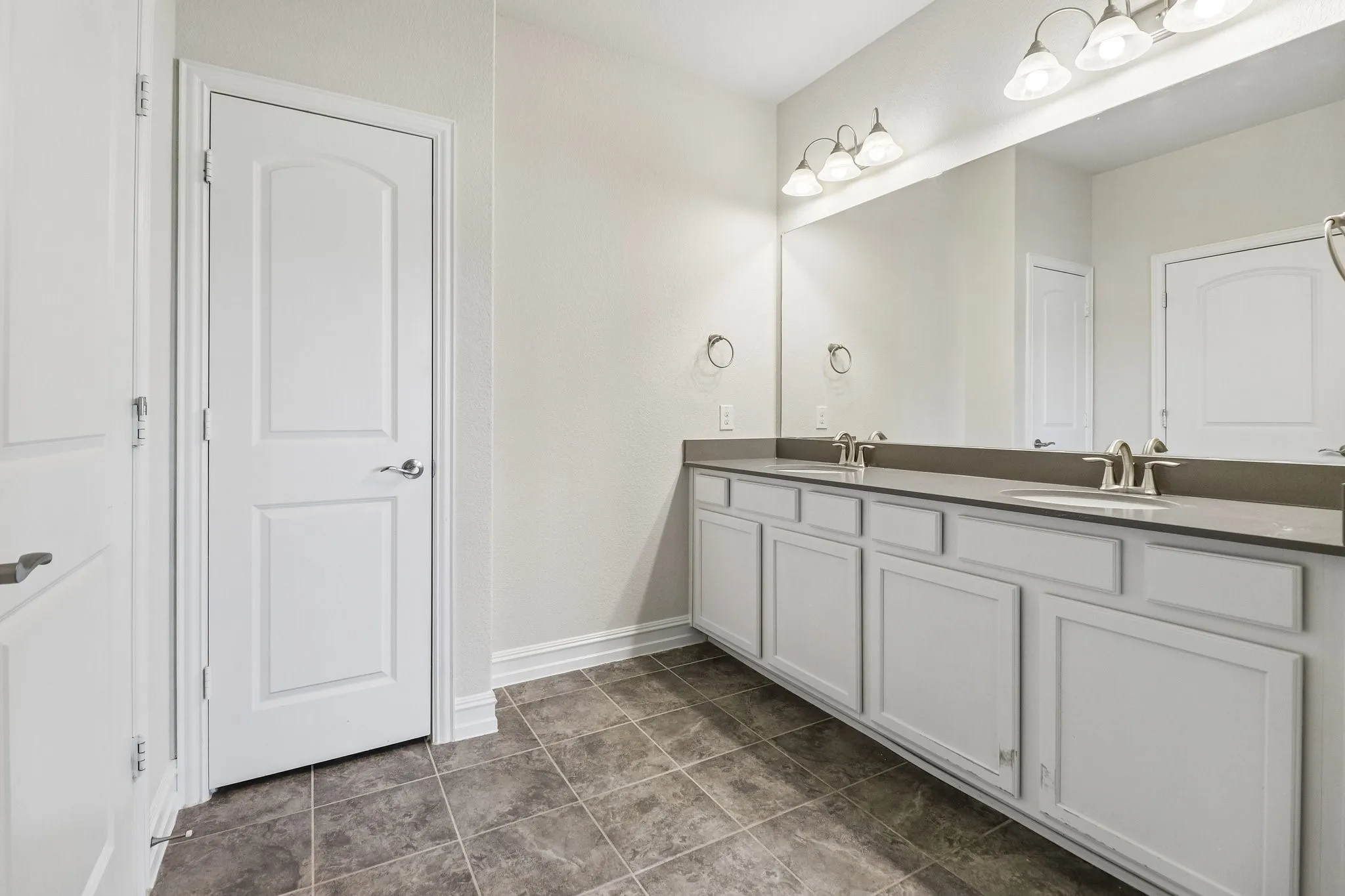 Dual vanity with undermount sinks, chrome fixtures, and a large mirror
