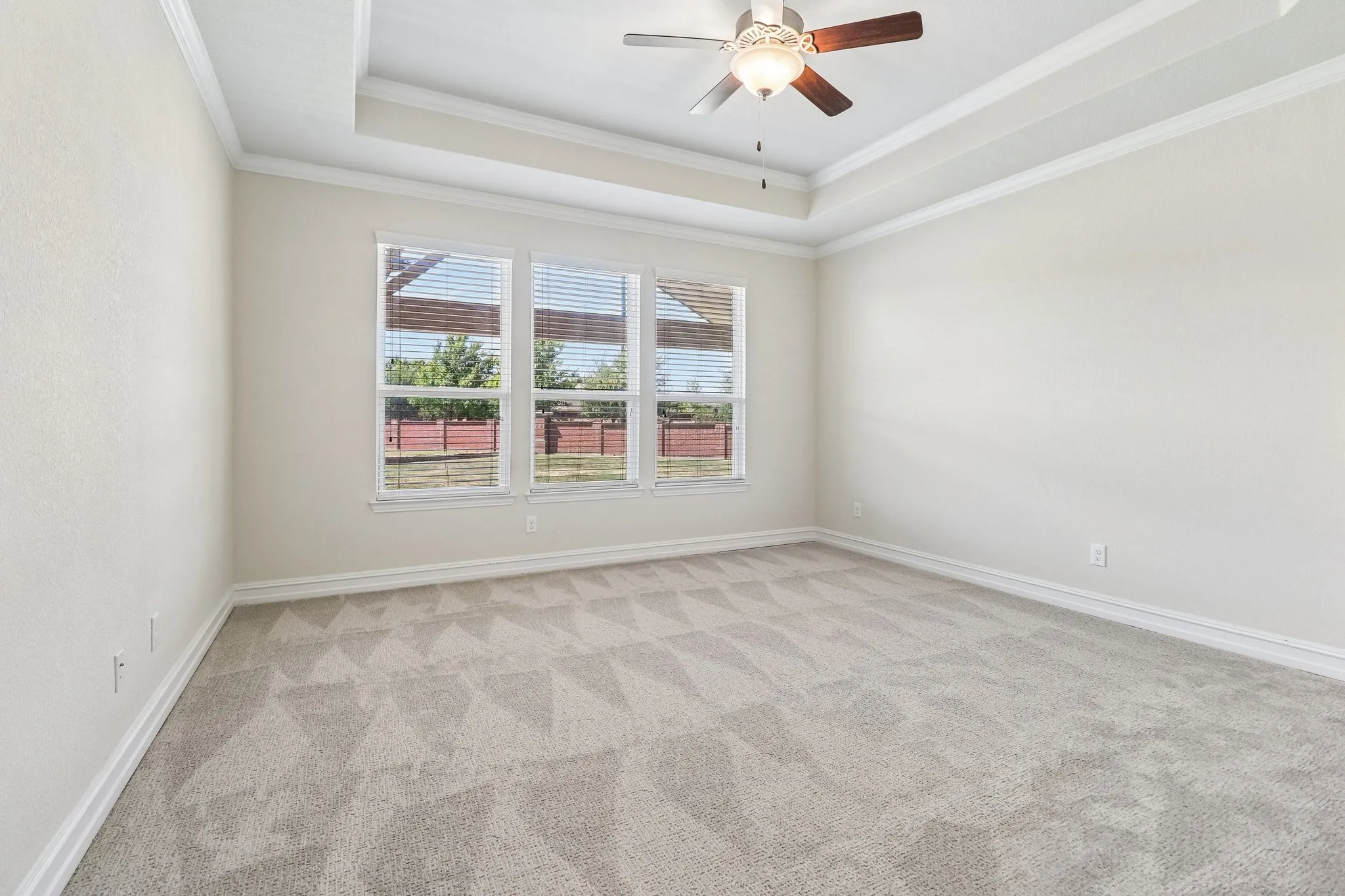 Tray ceiling with crown molding and a ceiling fan