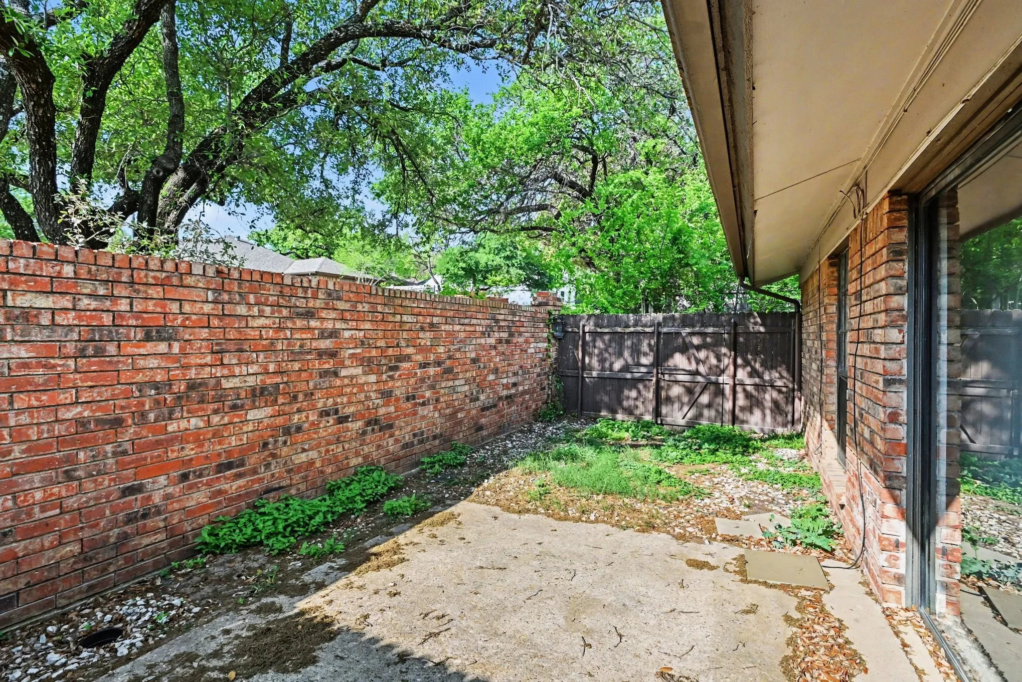 Paved patio area featuring brick exterior and large windows