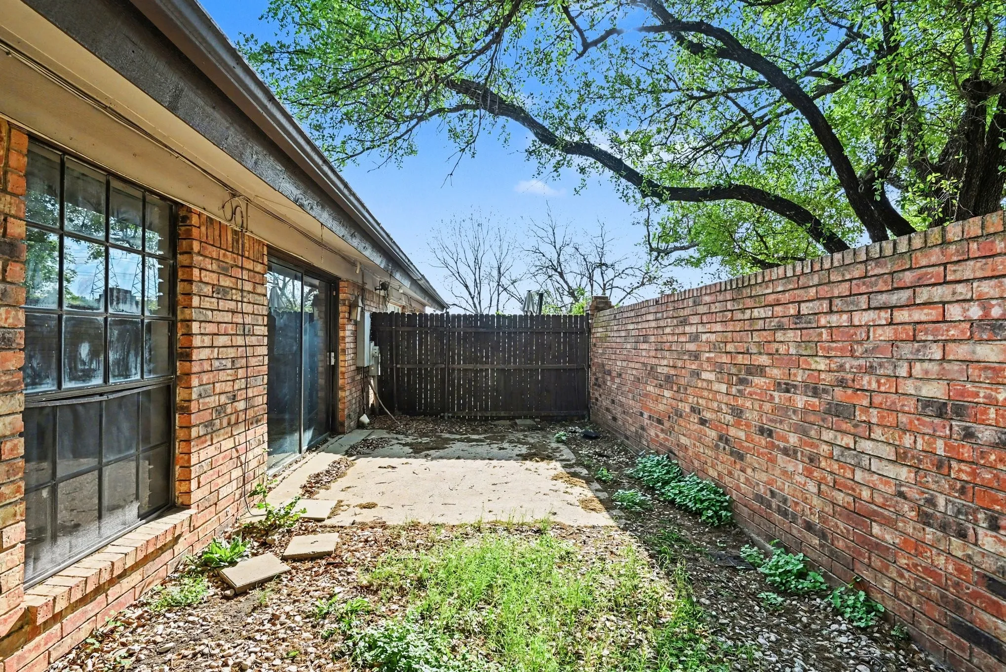 Brick exterior with large multi-pane window and sliding glass door