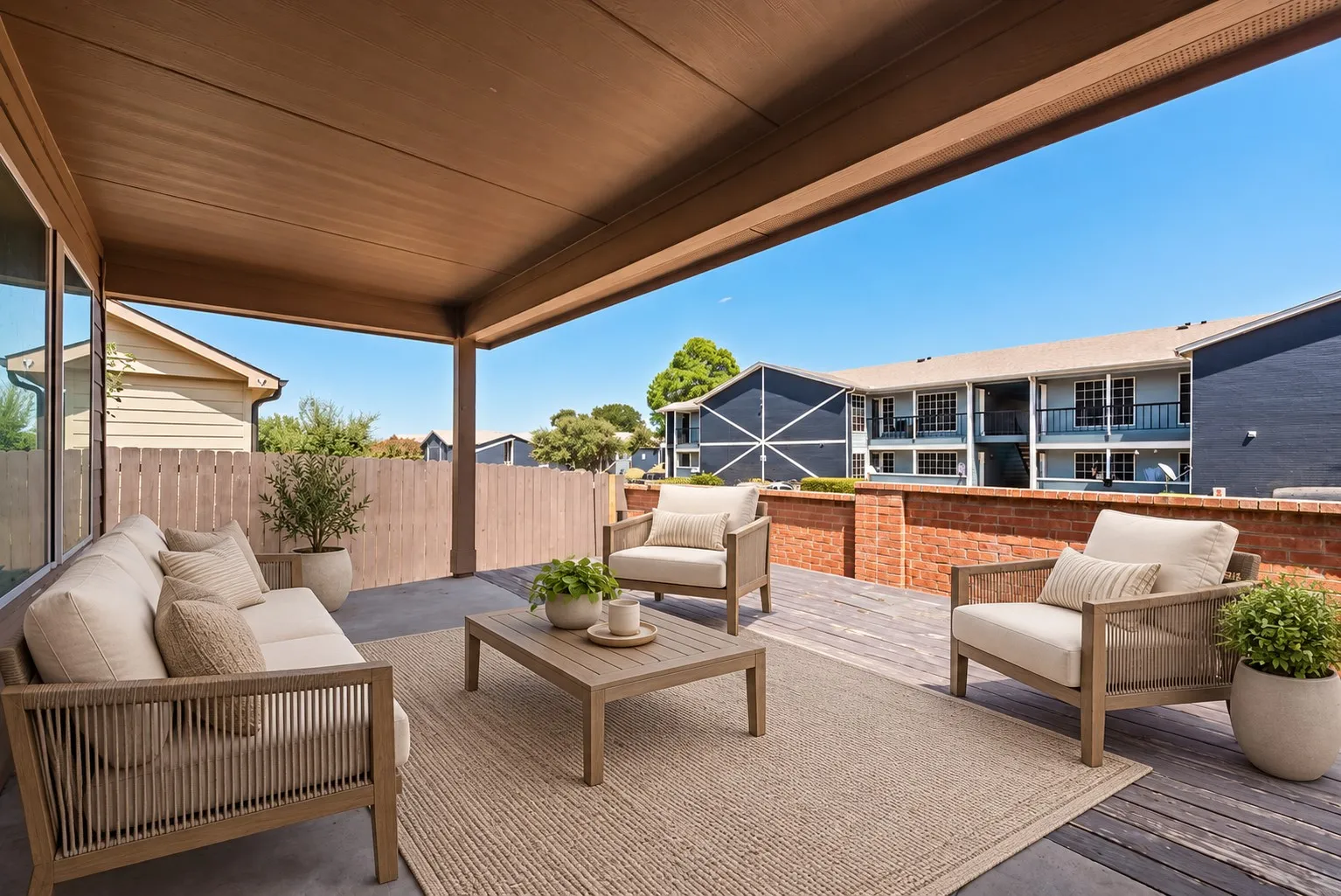Covered patio with a high ceiling, concrete flooring, and a partial privacy fence