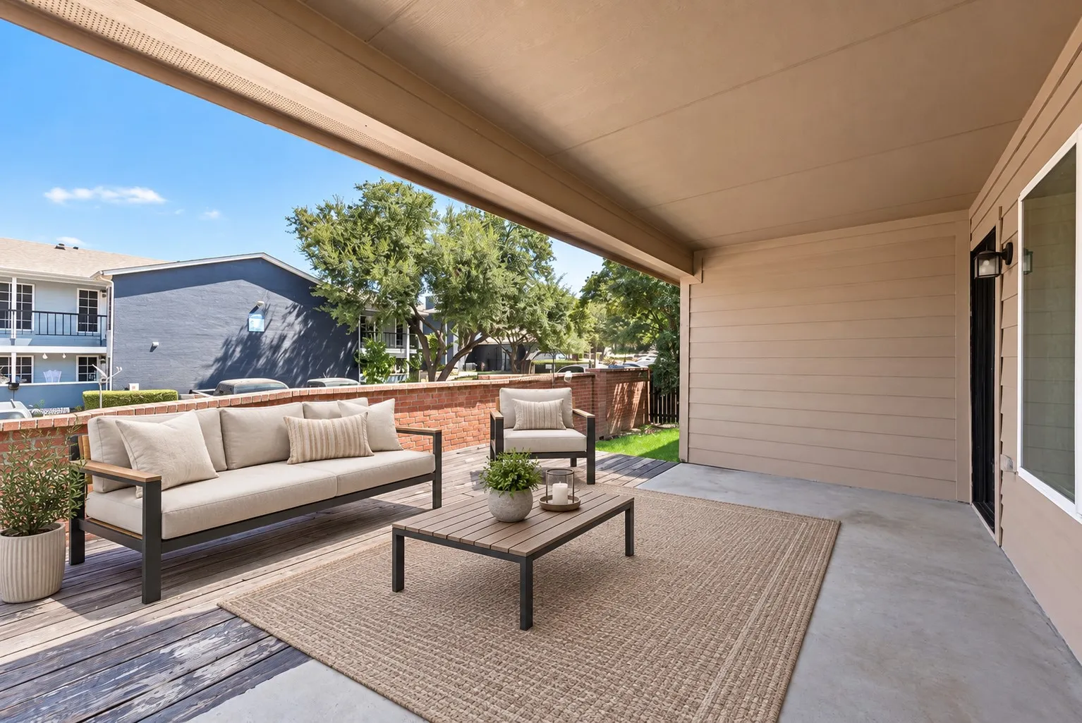 Covered outdoor patio featuring a concrete surface and a partial wood-finish deck