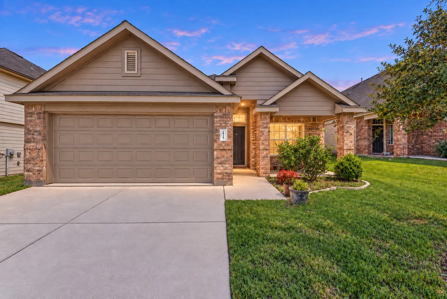 Brick and siding exterior with a covered entry, attached two-car garage, and concrete driveway