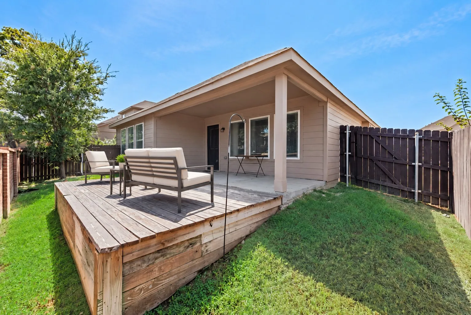 Covered patio with concrete flooring, wood deck, and fenced yard