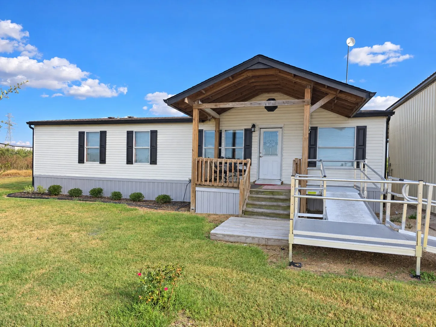 White siding exterior with black window shutters. ramp does not convey.