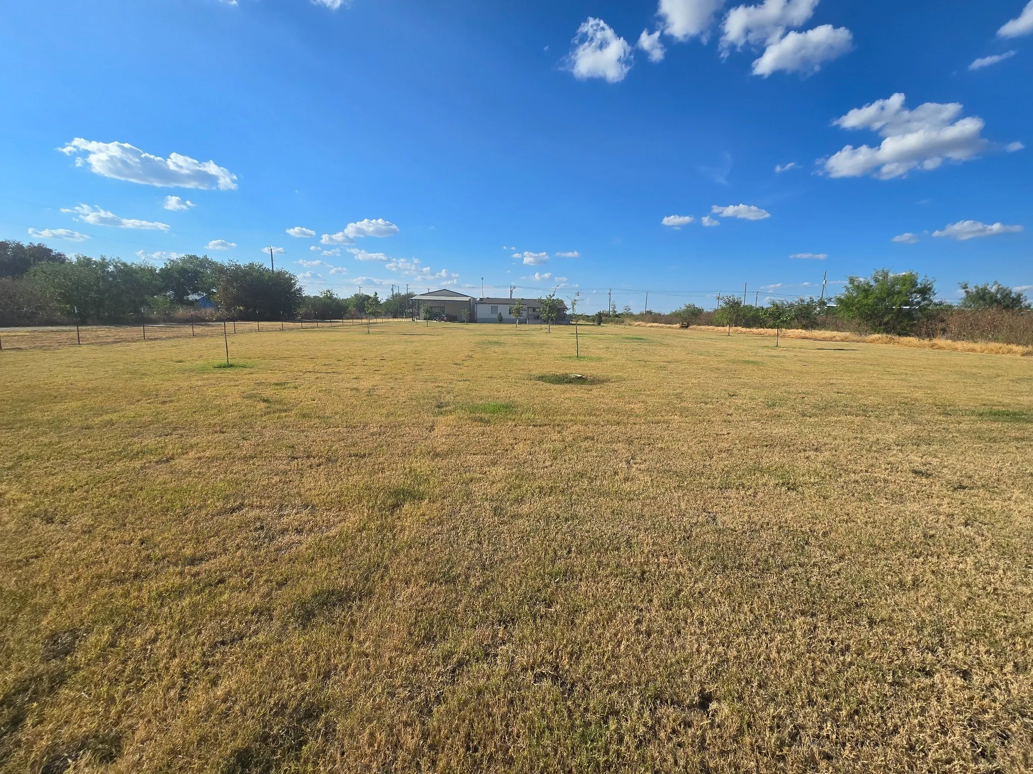 Expansive back land parcel with open fields and distant structures