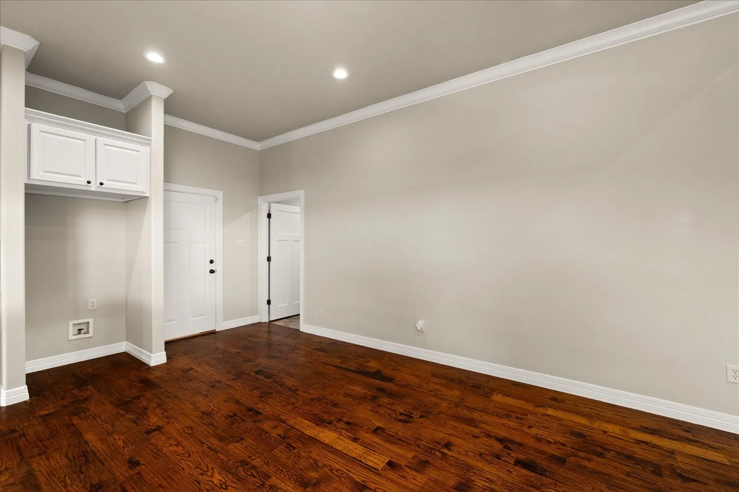 Hardwood flooring, crown molding, recessed lighting, white built-in cabinetry, and white paneled doors