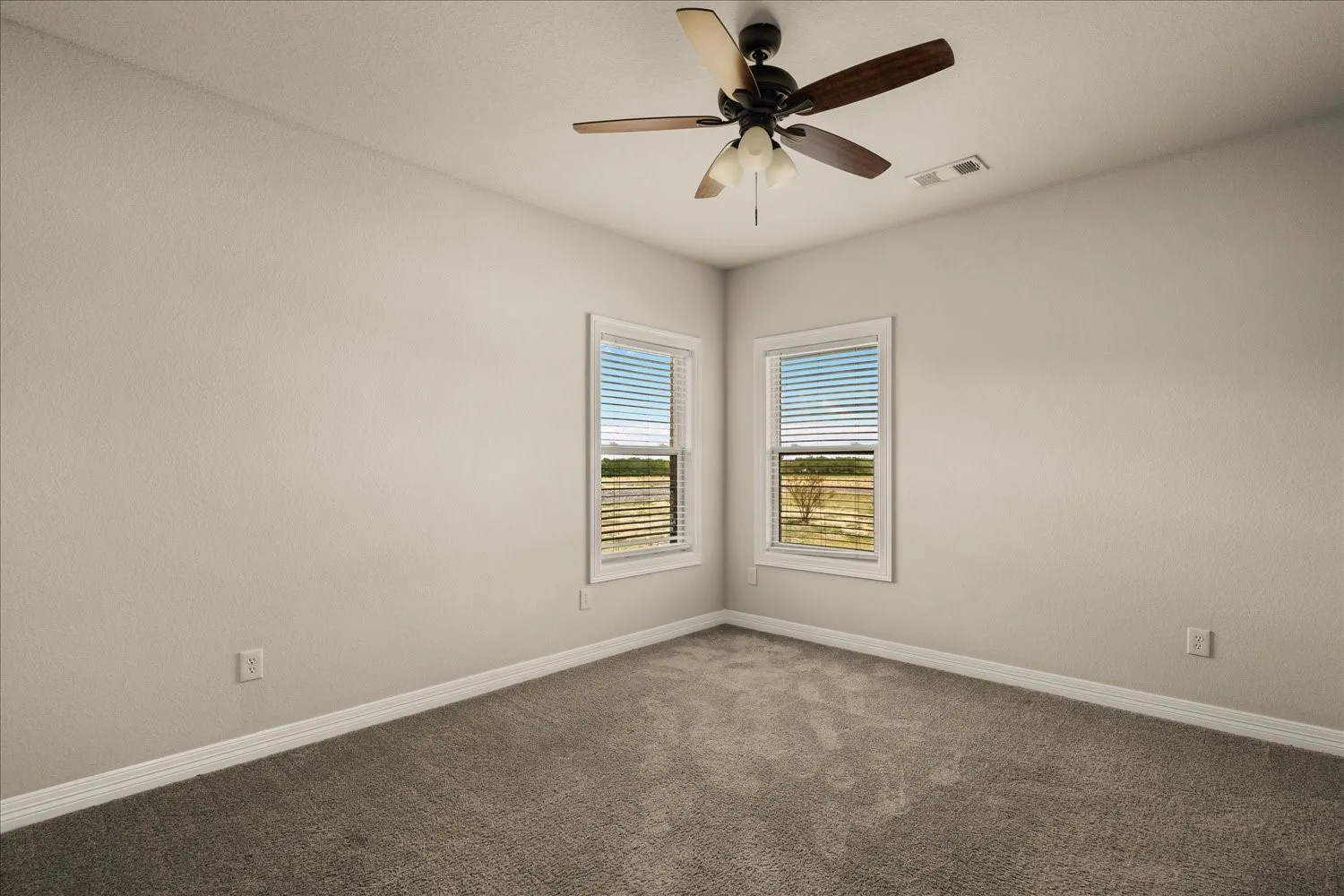 Recessed windows with blinds, ceiling fan with light fixture, neutral wall color, and carpeted flooring