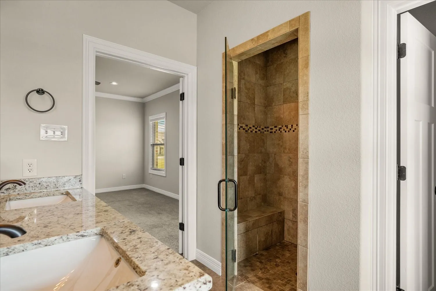 Shower with tiled walls, integrated bench, and mosaic accent