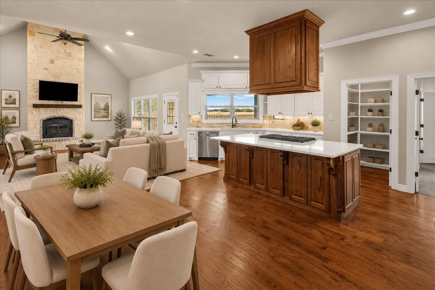 Vaulted ceilings, wood-finish flooring, stone-clad fireplace with mantel, kitchen island with built-in gas cooktop, and built-in shelving