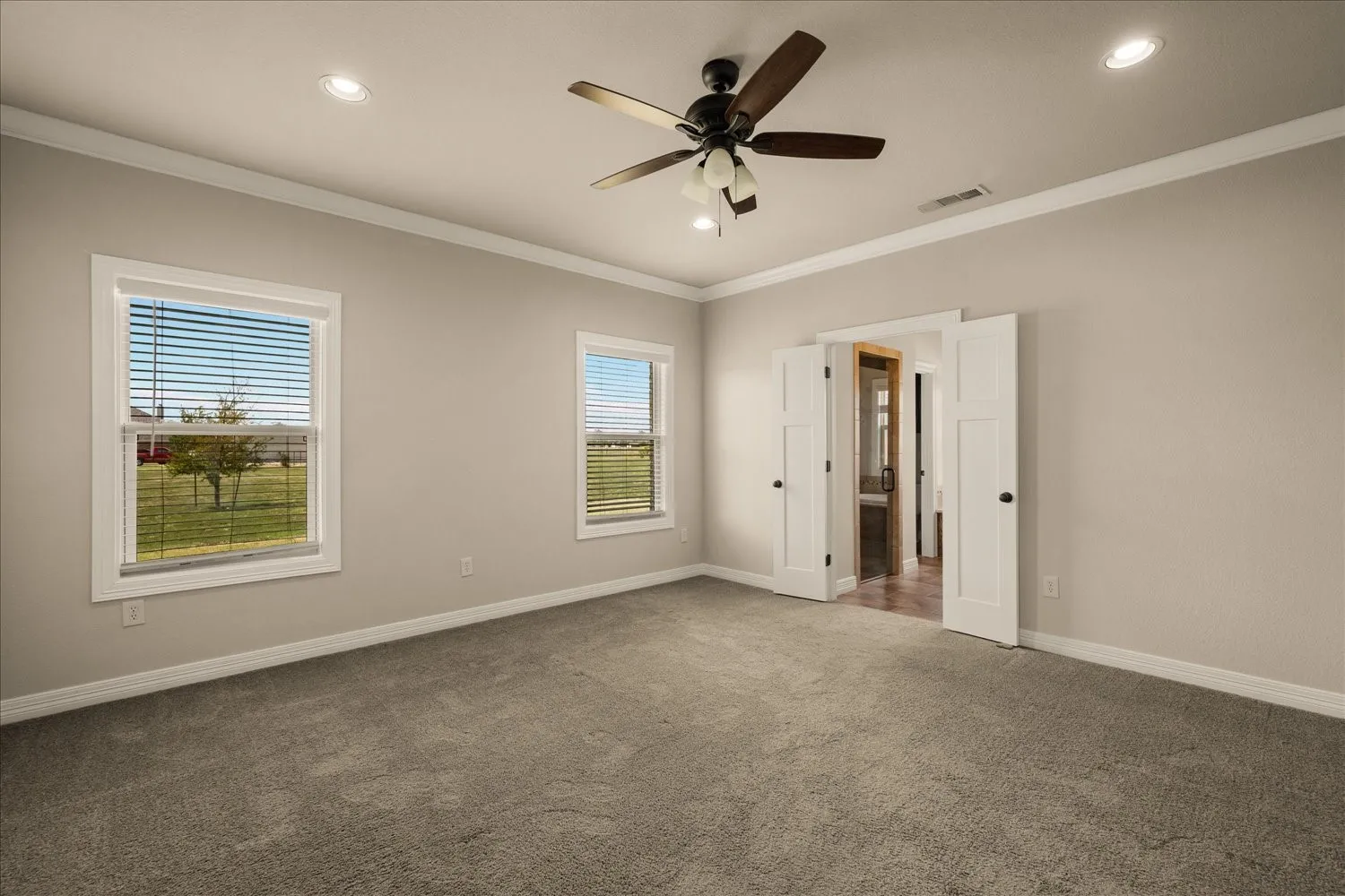 Recessed lighting, ceiling fan with light fixture, dual windows, neutral wall tones, and carpeted flooring