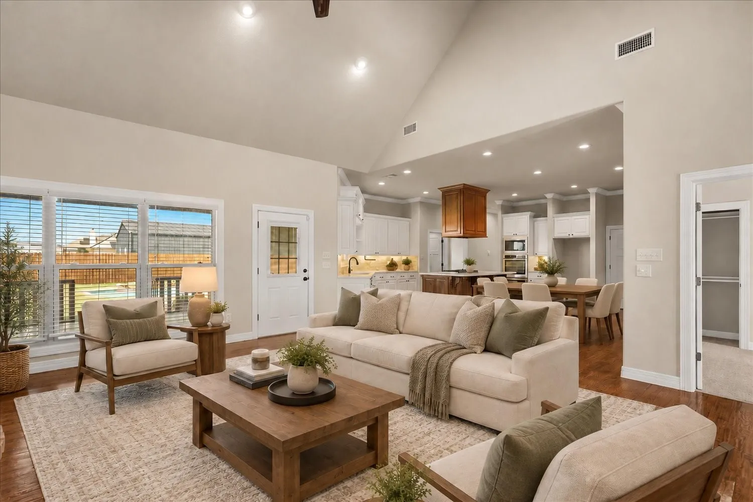 Vaulted ceiling, recessed lighting, wood-finish flooring, white trim, and a glass-paneled exterior door