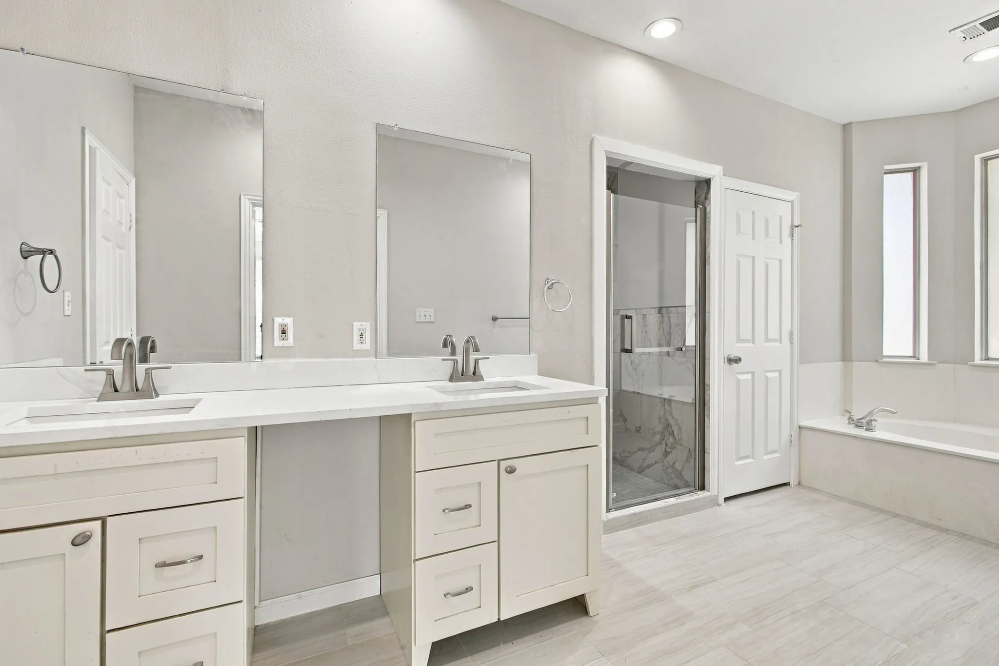 Dual vanity with undermount sinks, white countertops, and brushed nickel fixtures