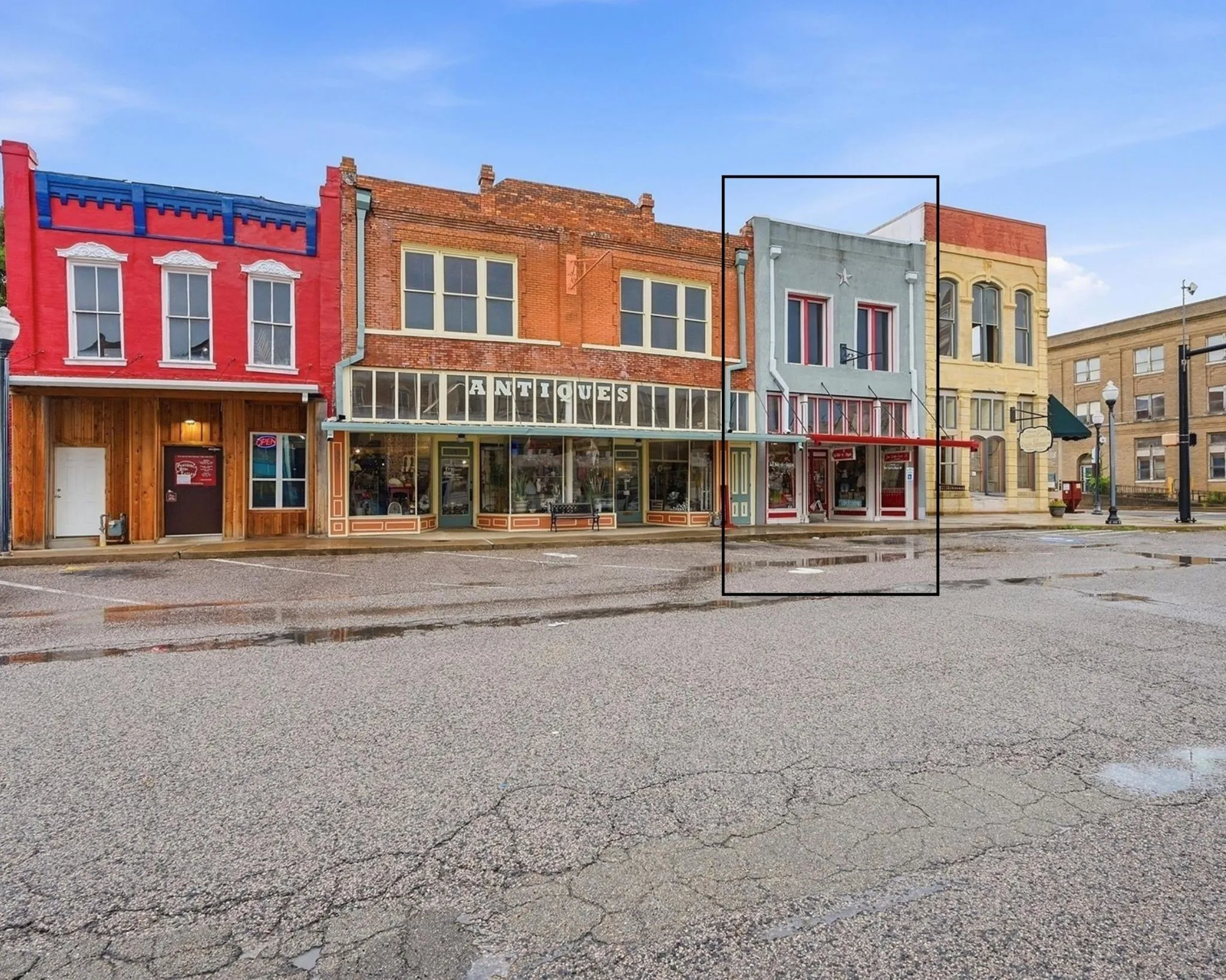 Front of Structure / Subject Property is the red and gray building.