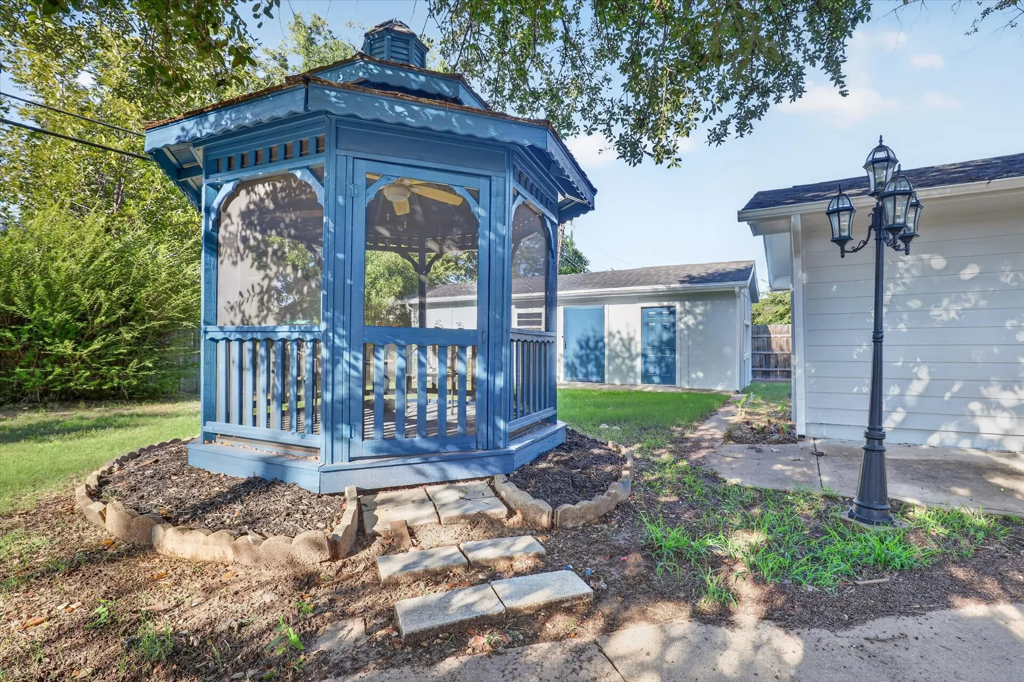 Blue gazebo featuring a cupola roof and screened sides