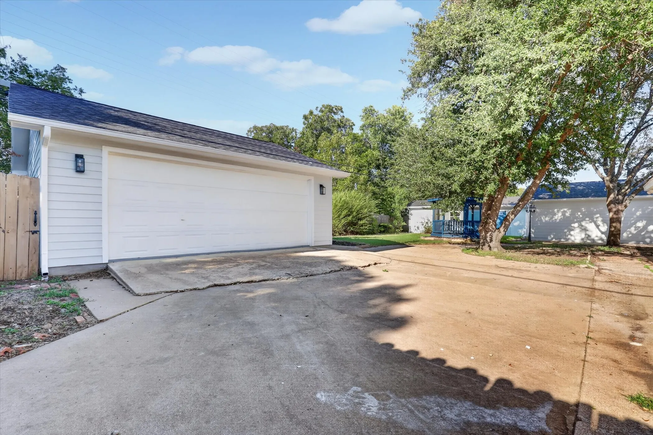 White paneled garage door with wall-mounted exterior lighting