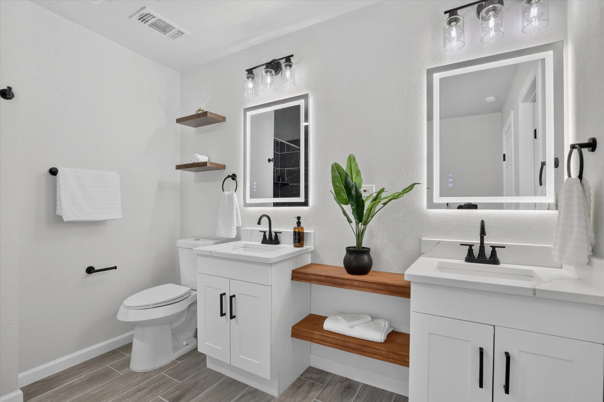 Dual vanity with white cabinetry, matte black hardware, and integrated sinks