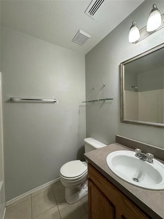 Bathroom featuring a vanity with an integrated sink, wood-finish cabinetry, neutral countertop, and a wall-mounted mirror