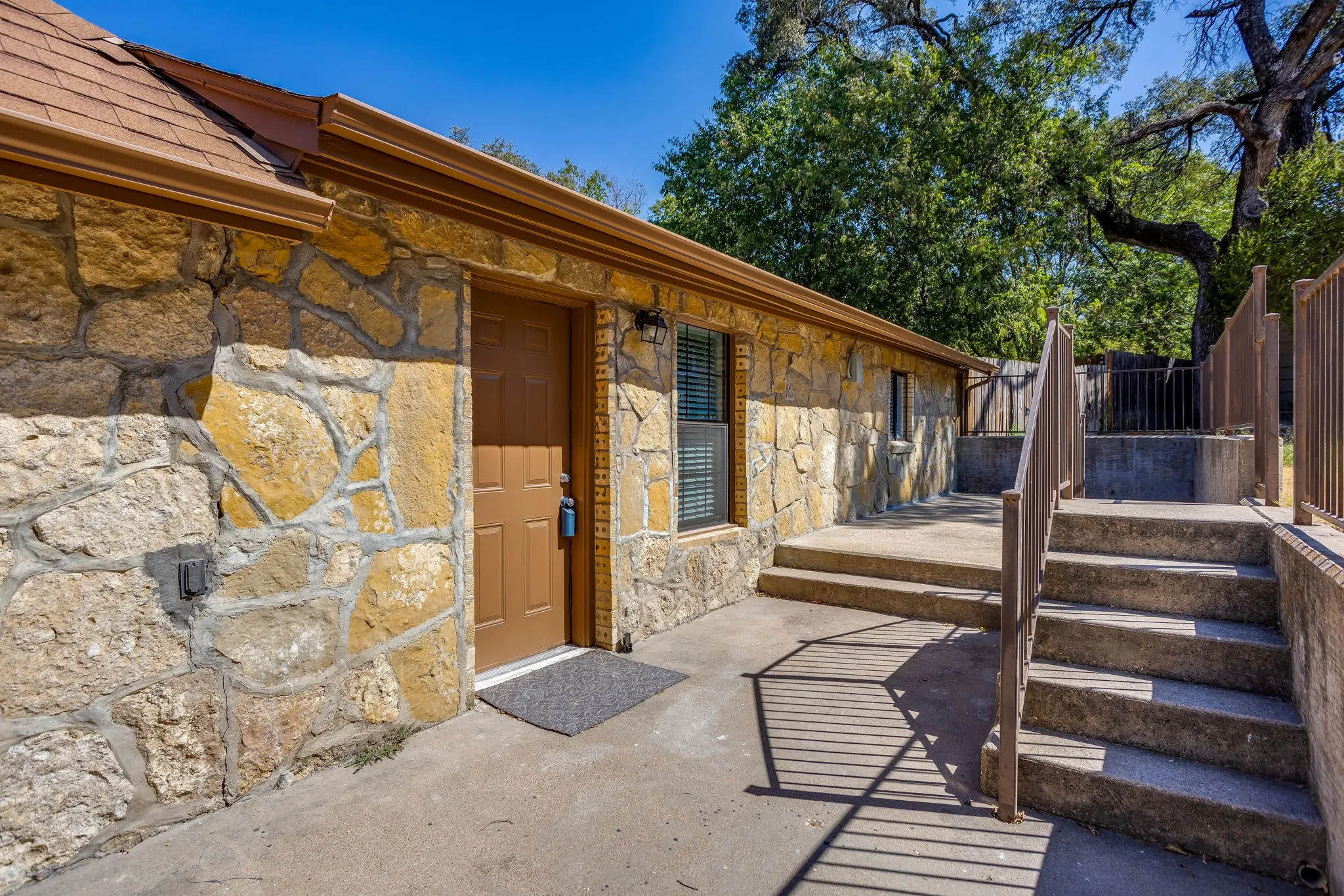 Stone veneer exterior with brown door and window