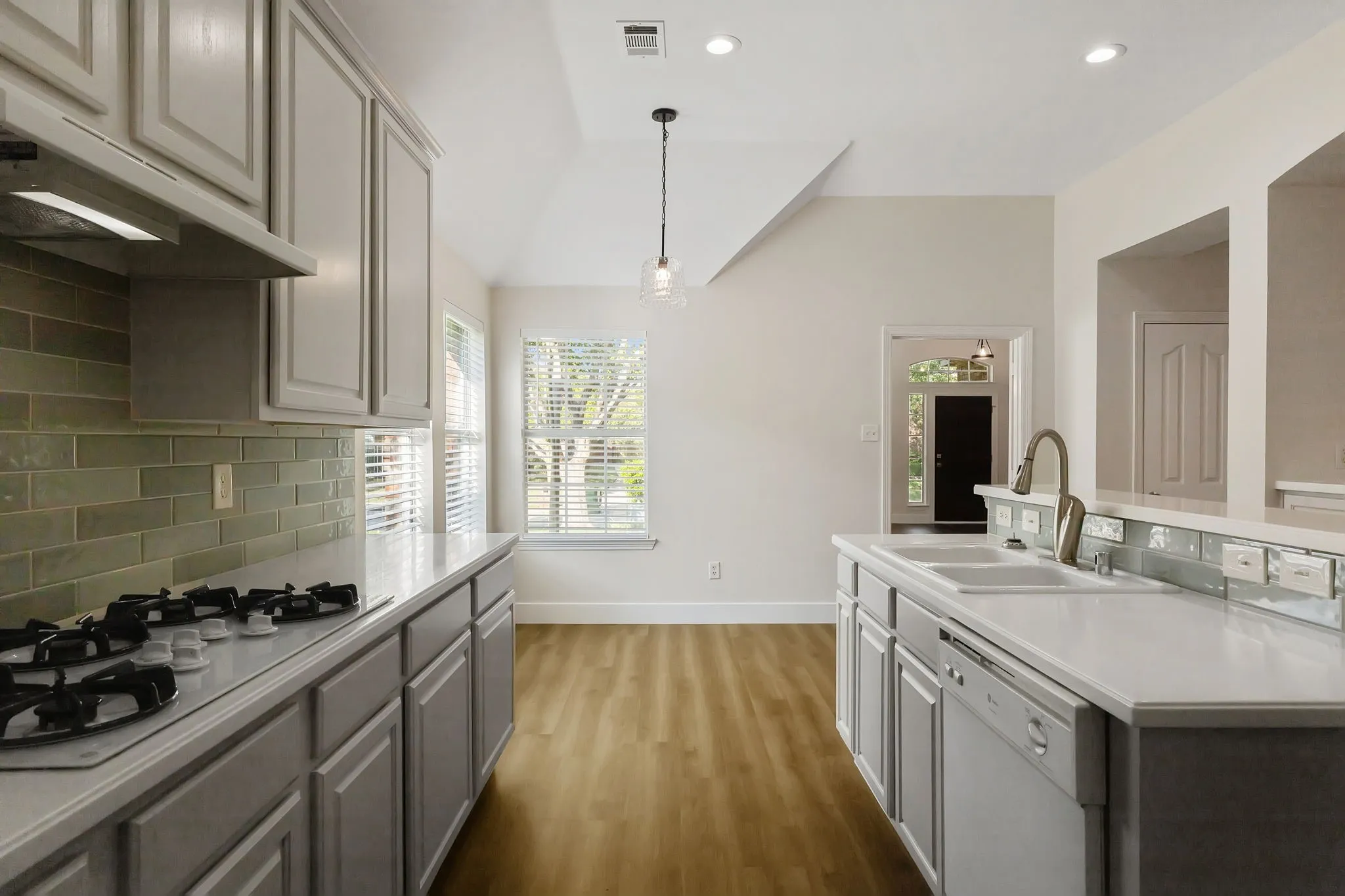 Kitchen featuring light-finish cabinetry, white countertops, subway tile backsplash, and wood-finish flooring