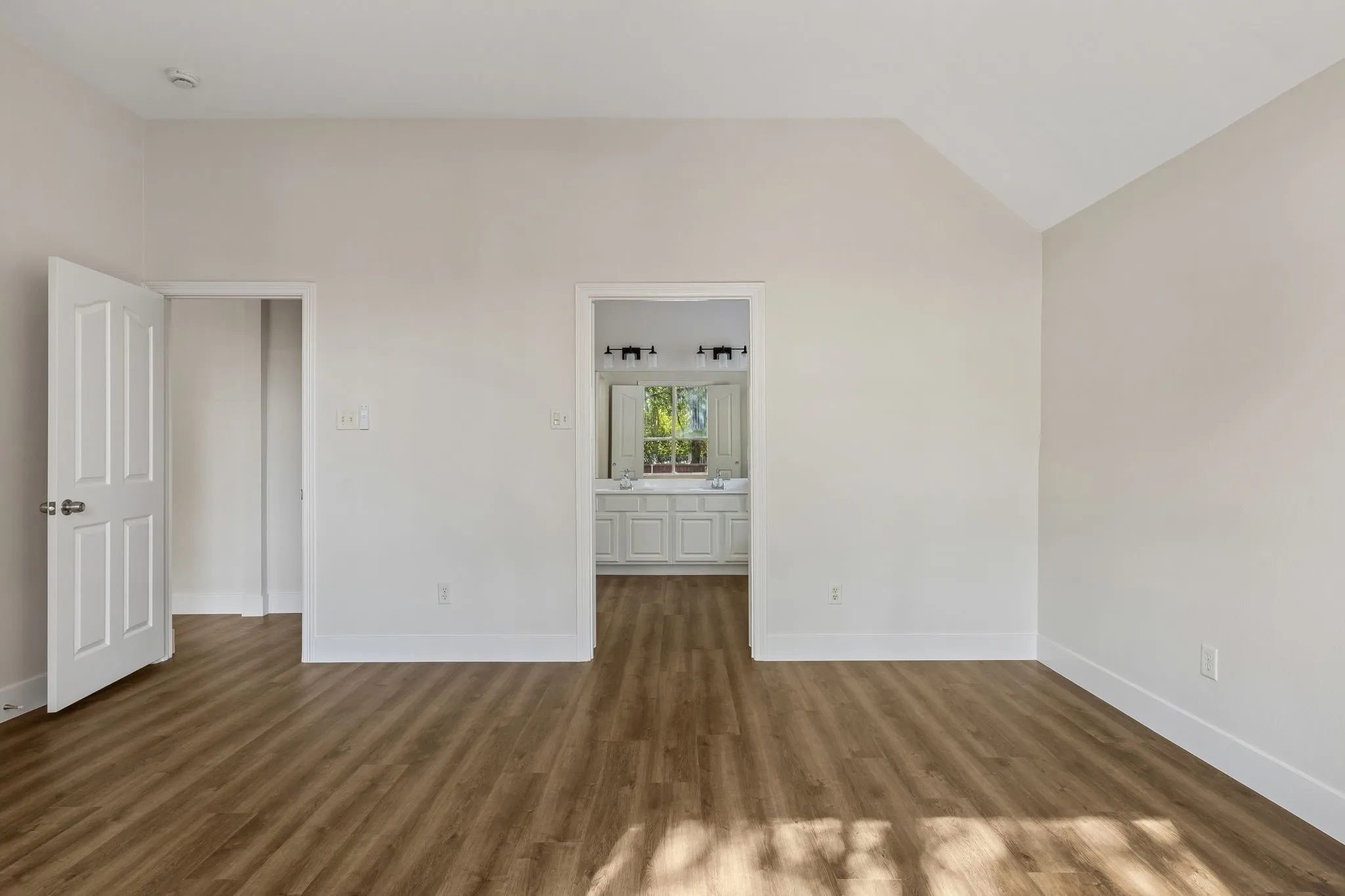 Wood-finish flooring throughout, vaulted ceiling, and recessed lighting