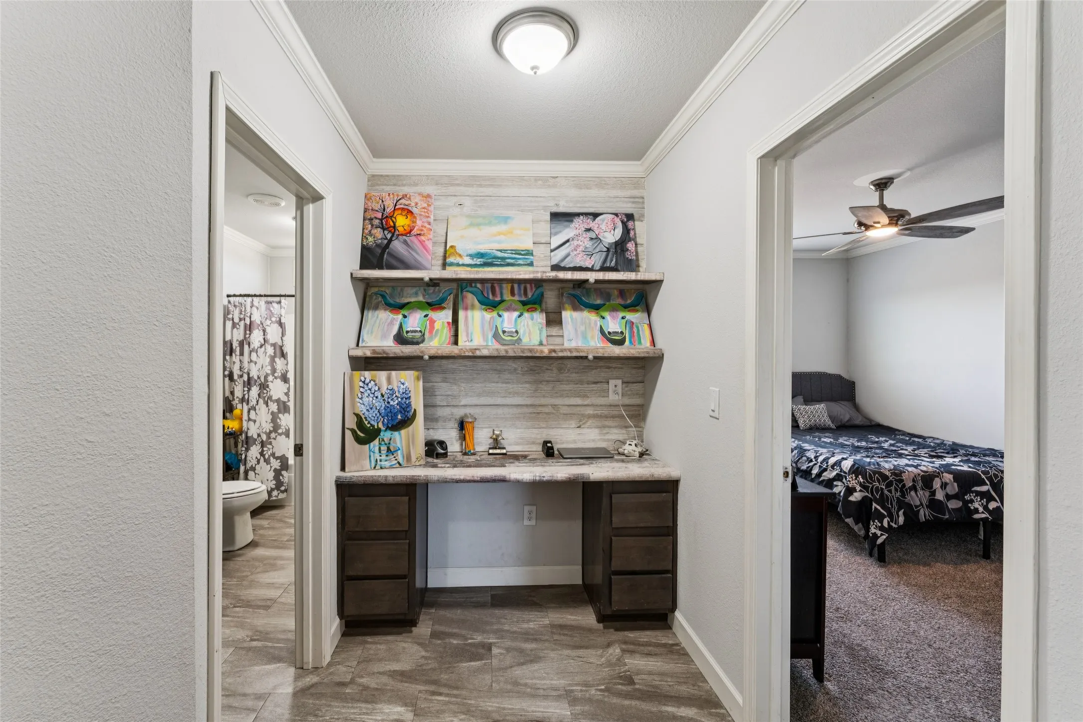 Built-in desk with dark wood-finish cabinetry, floating shelves, and plank accent wall