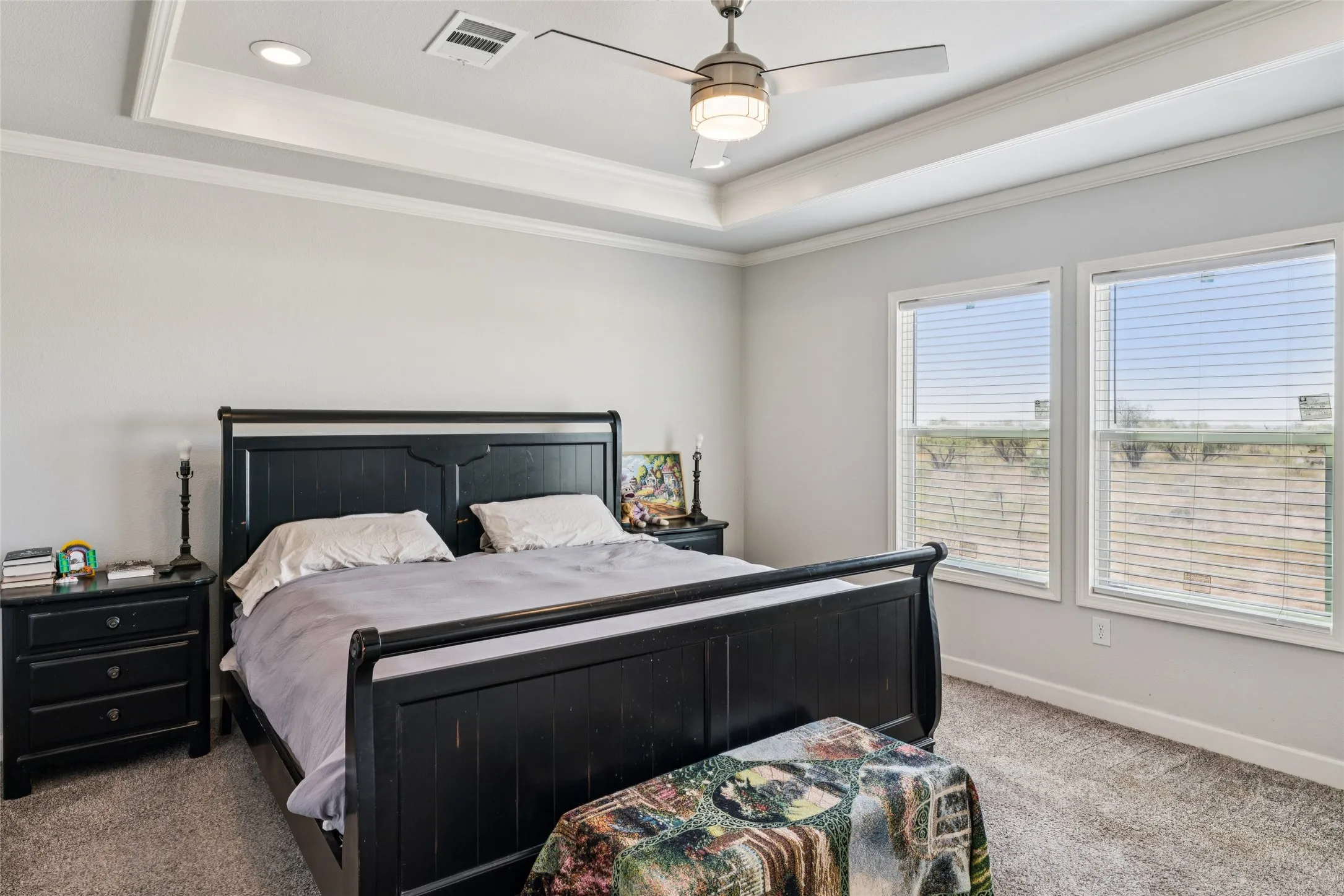 Primary bedroom with coffered ceiling and crown molding, ceiling fan, and dual pane windows with blinds