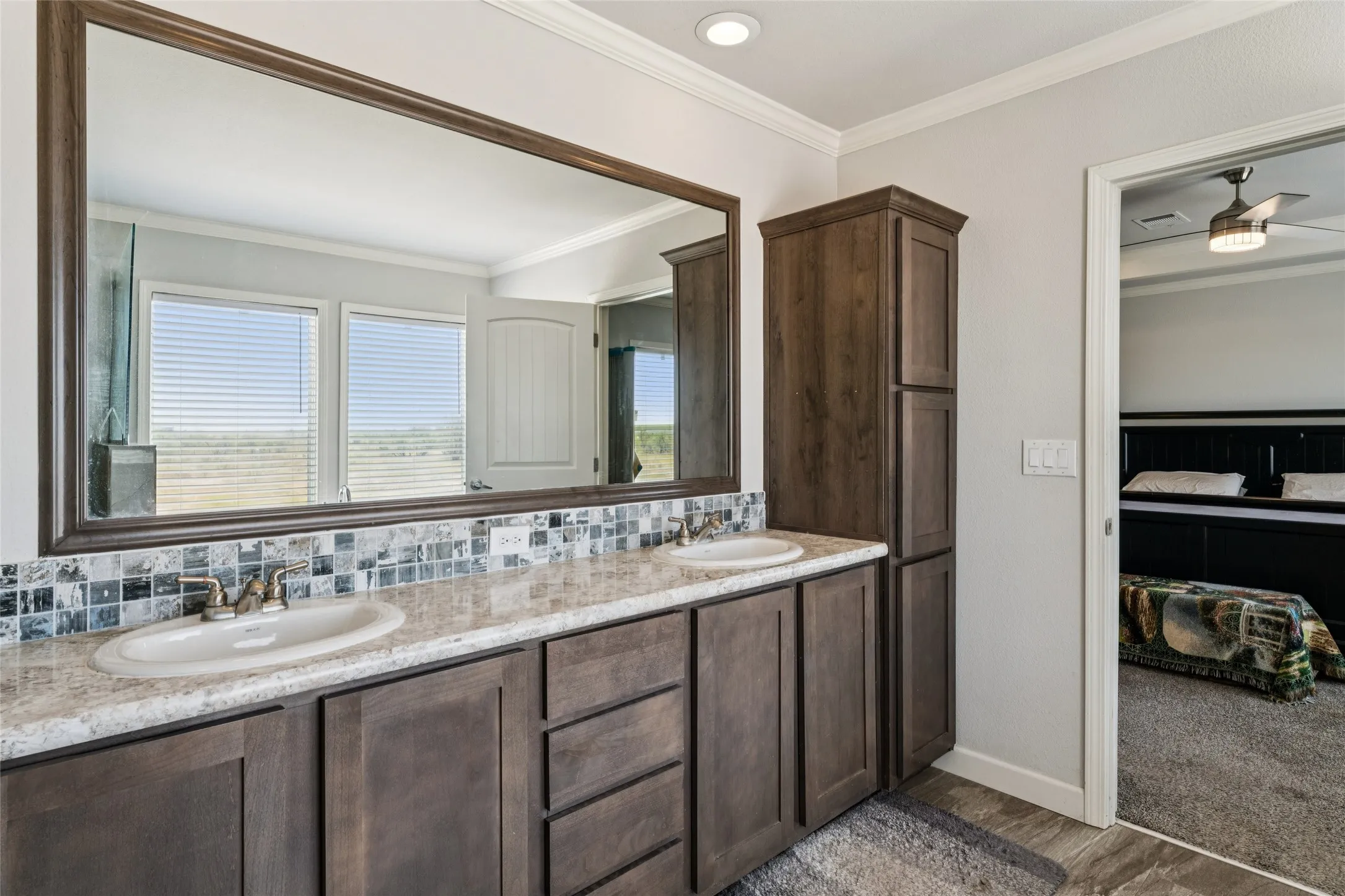 Dual vanity with under-mount sinks, patterned tile backsplash, and a large framed mirror