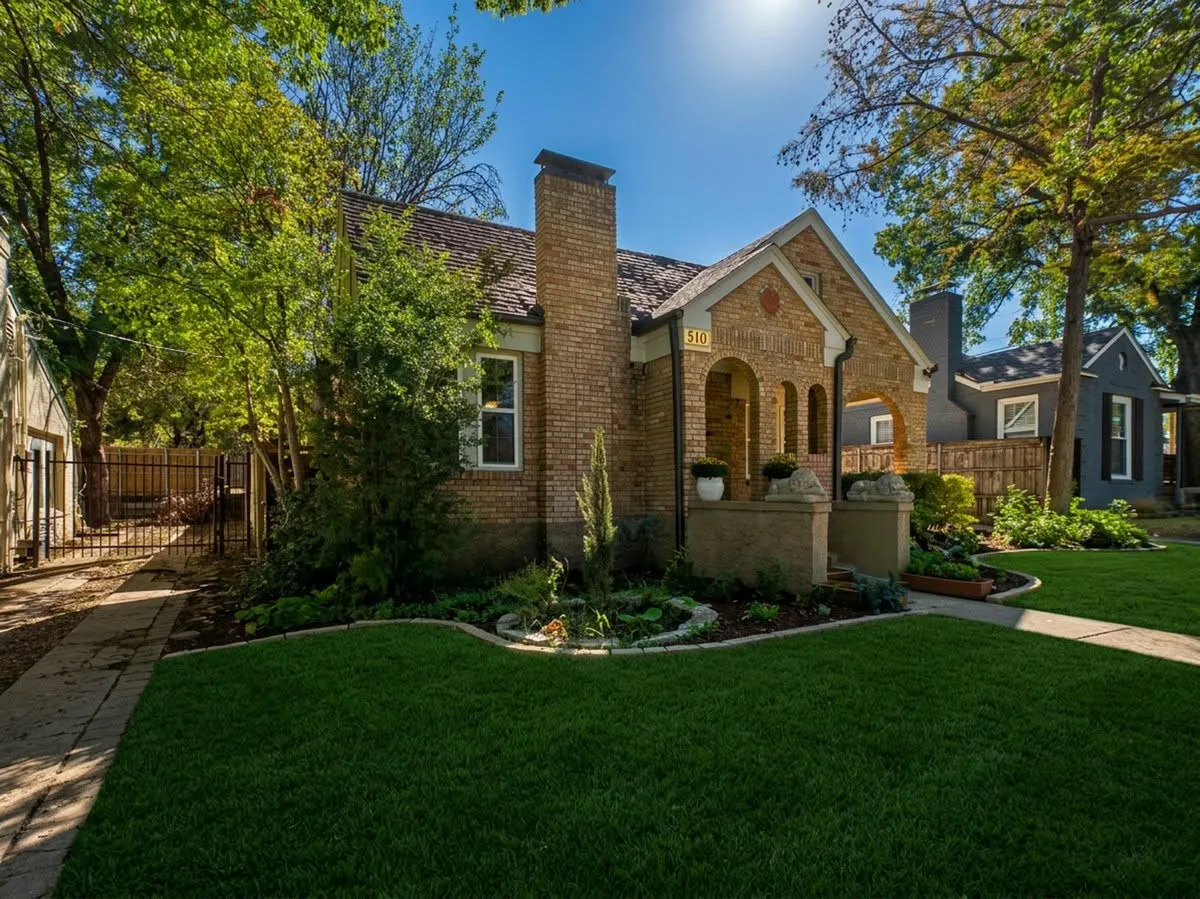 Brick exterior with an arched entryway, gabled roofline, and a prominent brick chimney