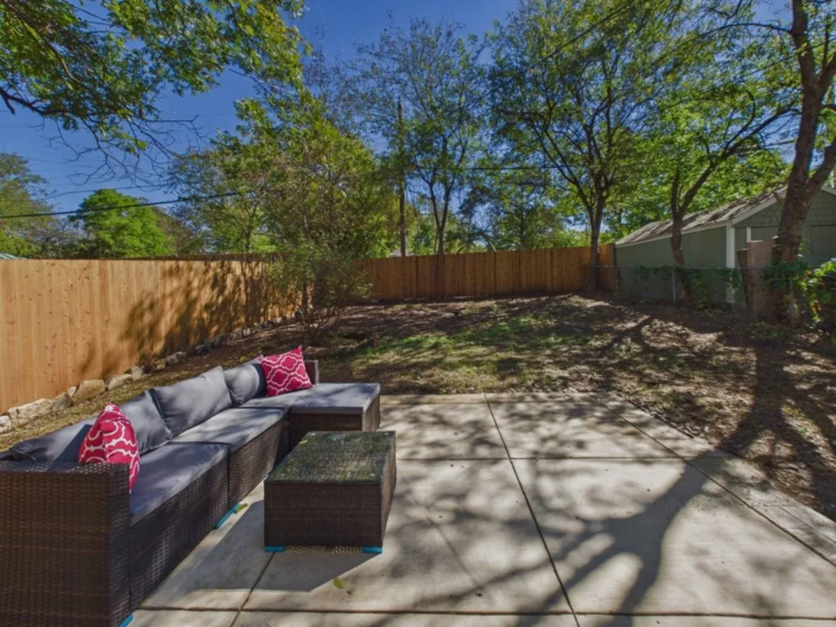 Expansive concrete patio with a new wood privacy fence
