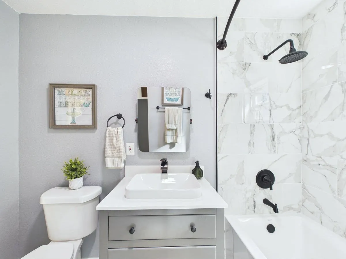 Bathroom featuring a vanity with a rectangular basin, white countertop, and gray cabinetry