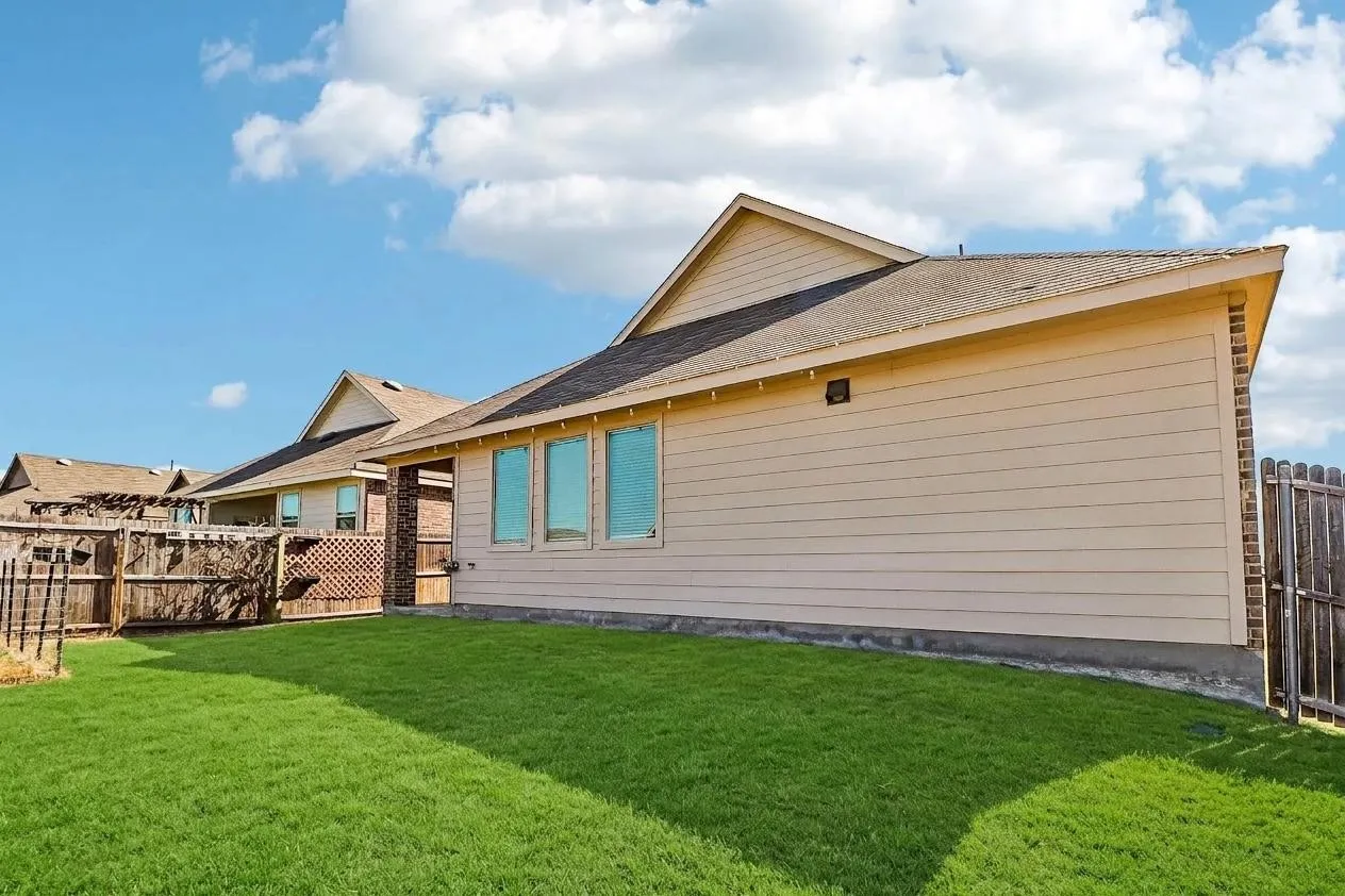 Expansive green lawn with a wood fence perimeter