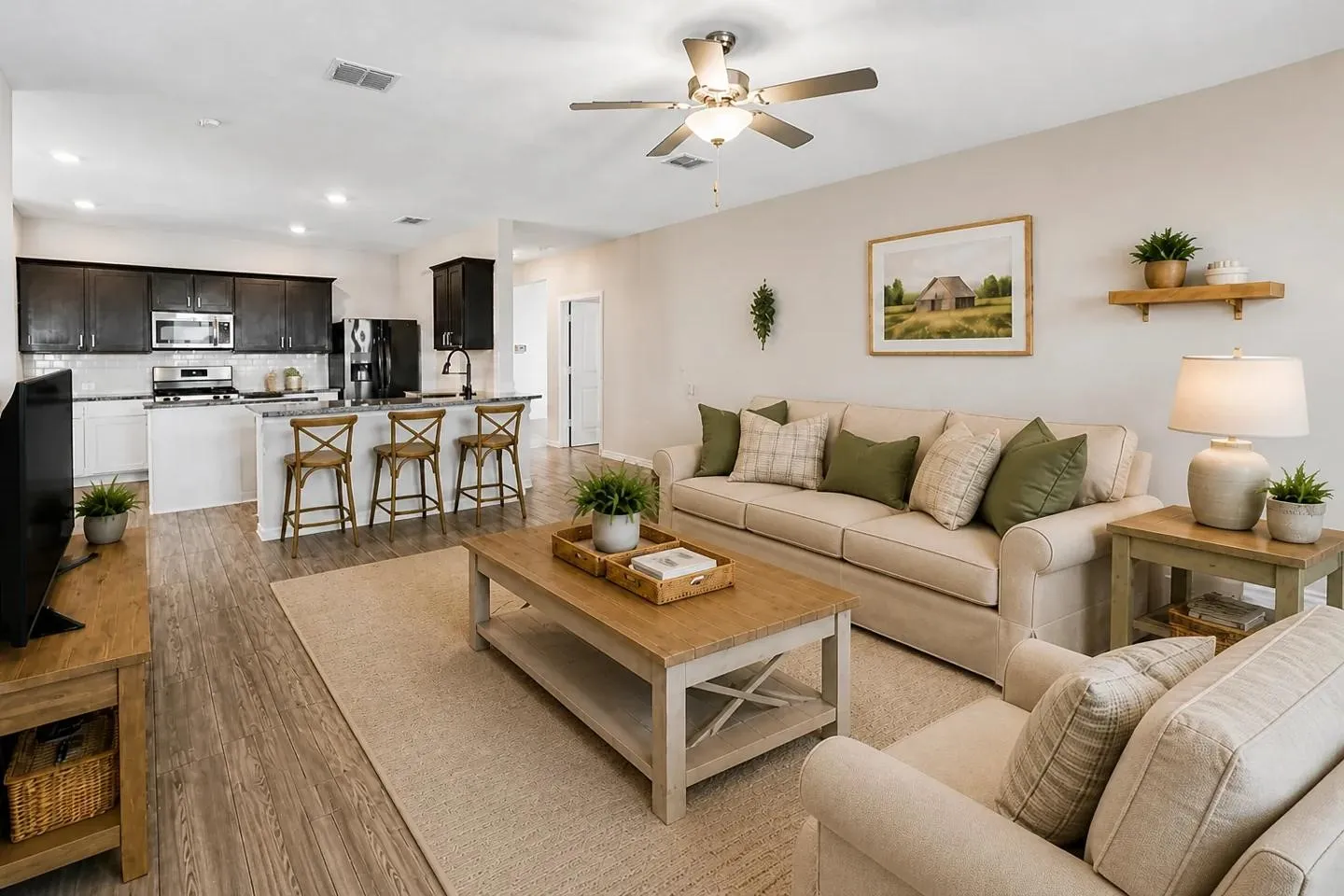 Virtually Staged
concept living space featuring wood-finish flooring, a kitchen island with seating, dark wood cabinetry, and a ceiling fan