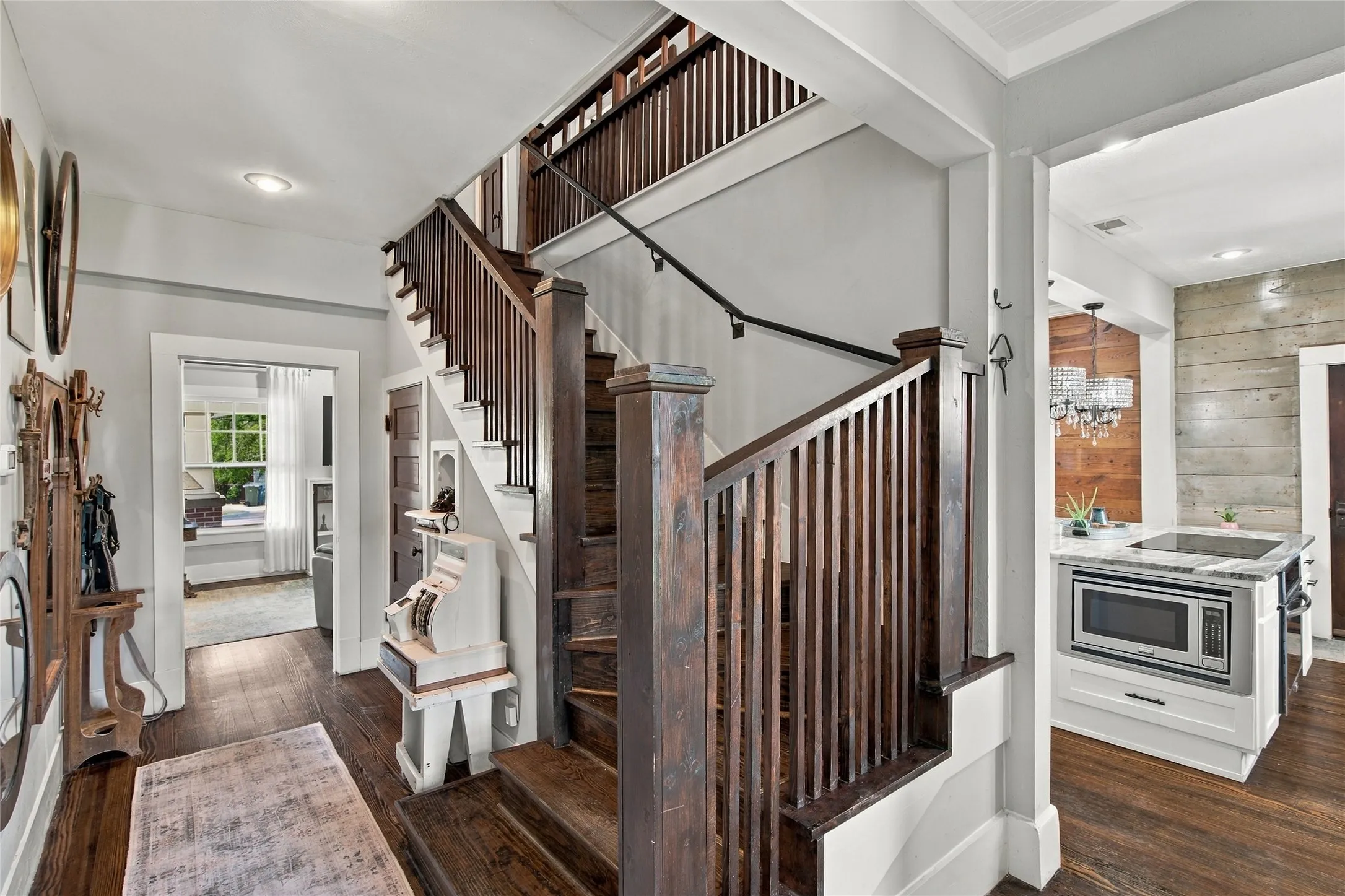 The original grand staircase featuring dark wood newel posts and railings centers the home.