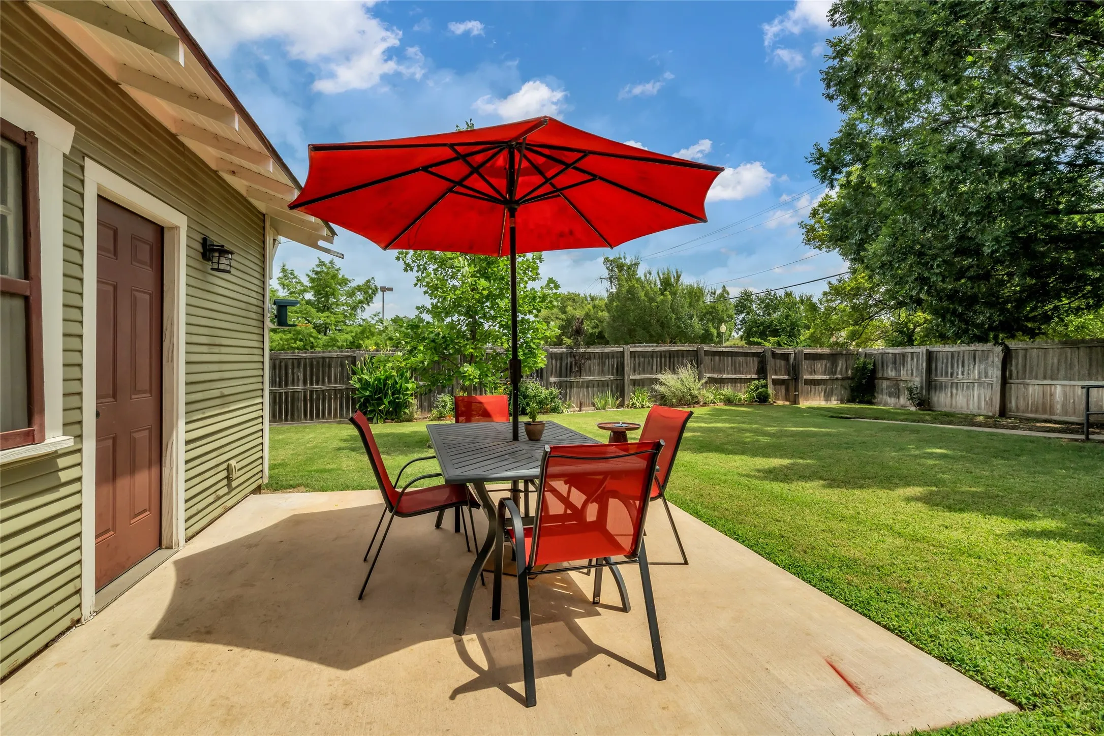 Expansive backyard with second patio, a manicured lawn, and wood fence